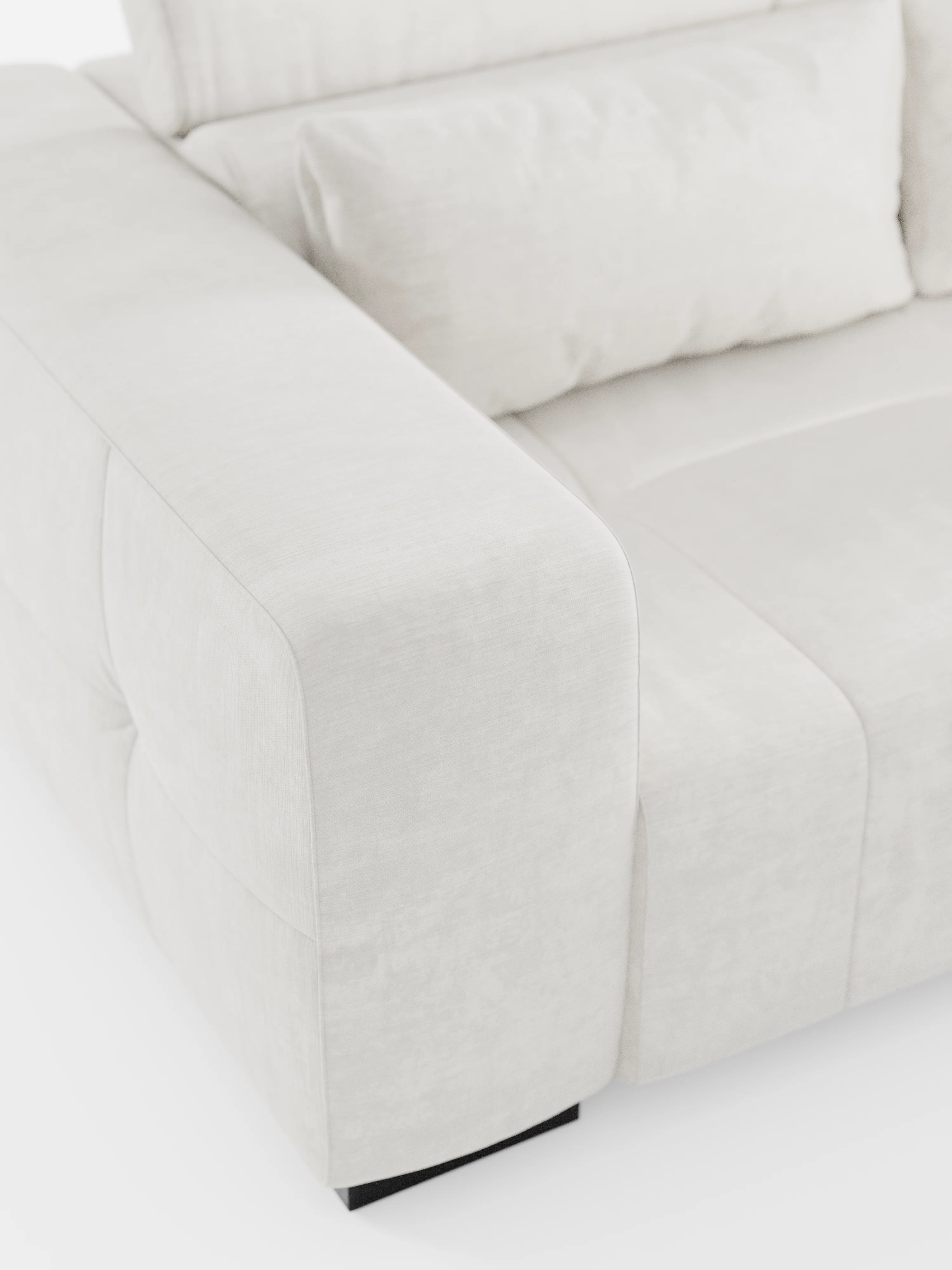 Primo piano del divano Monarch con funzione relax elettrica per l’allungamento delle sedute e poggiatesta reclinabile, realizzato in morbido tessuto lavabile T31 di Divani.Store. L’immagine mette in risalto i braccioli, la seduta e lo schienale spessi e imbottiti, esaltando il tessuto morbido e liscio e i delicati dettagli delle cuciture. Questo elegante divano dal design contemporaneo poggia su gambe basse nere su uno sfondo bianco.