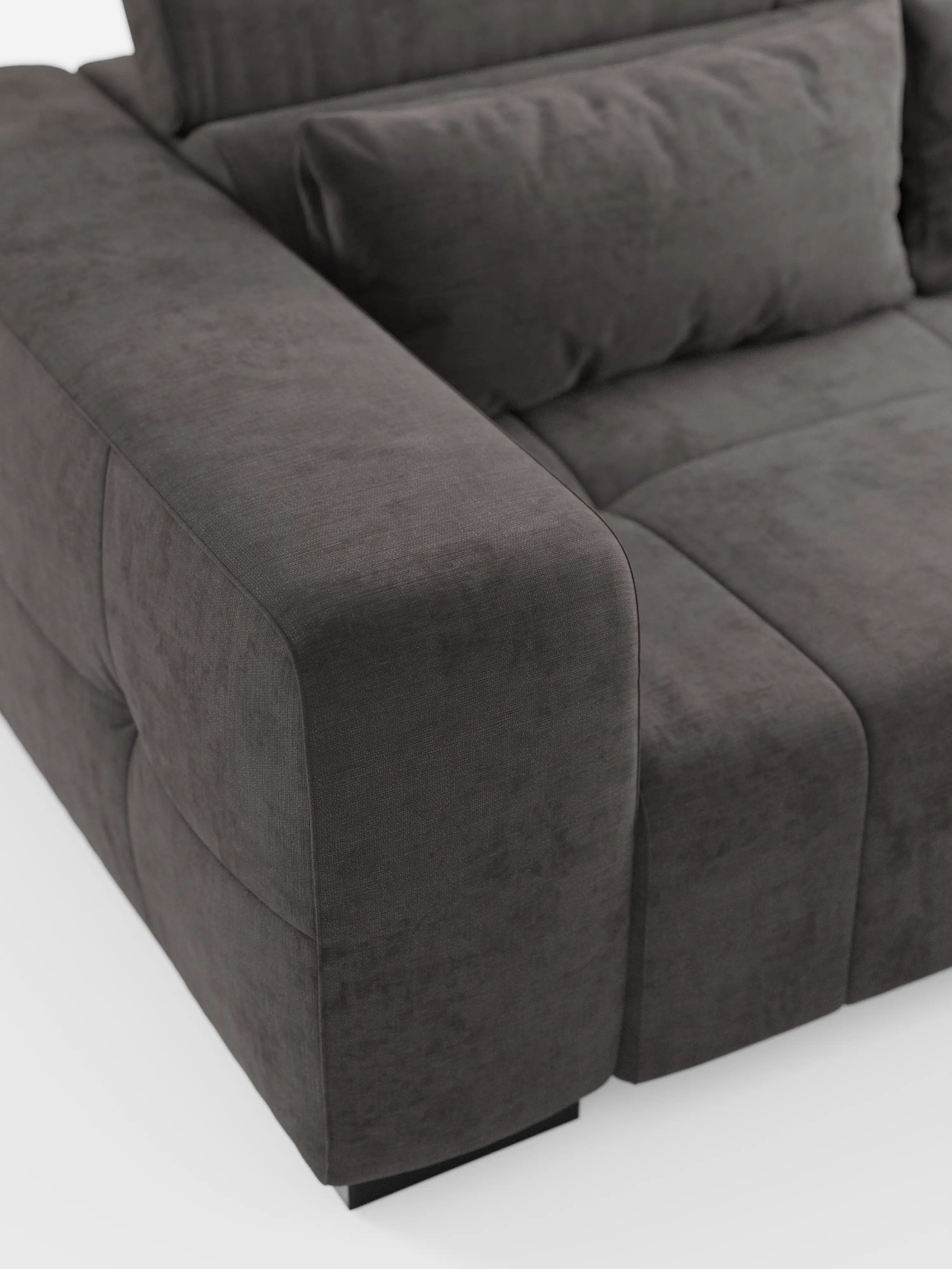 Primo piano del divano Monarch con funzione relax elettrica per l’allungamento delle sedute e poggiatesta reclinabile di Divani.Store, presentato in un moderno tessuto T31 grigio scuro, leggermente testurizzato, morbido e facile da pulire. L'immagine mette in risalto i suoi ampi braccioli, lo schienale imbottito e la seduta, con il divano sostenuto da piccole gambe nere su uno sfondo bianco a tinta unita.