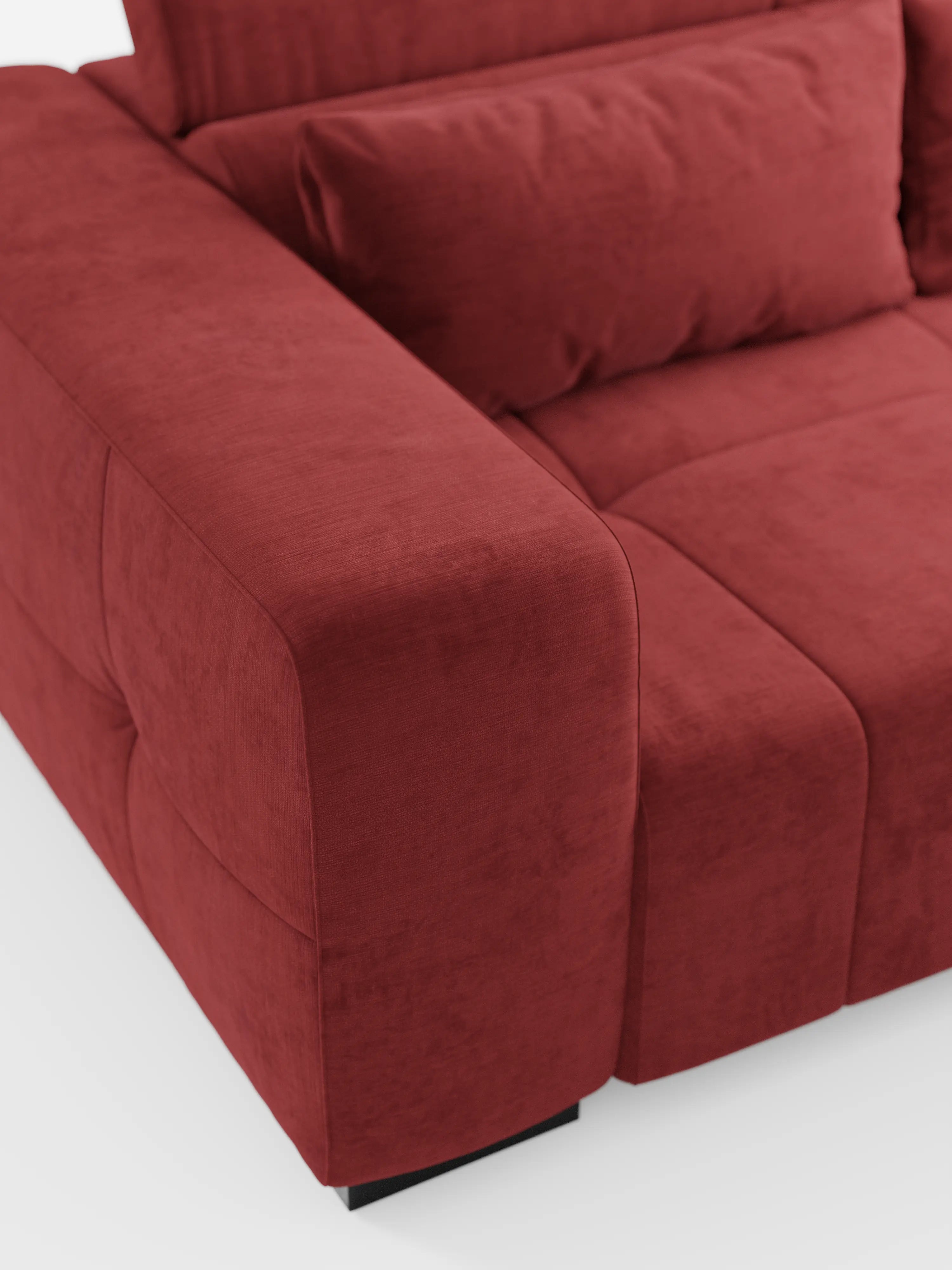 Un primo piano del divano Monarch con funzione relax elettrica per l’allungamento delle sedute e poggiatesta reclinabile di Divani.Store, rivestito in tessuto T31 rosso intenso, morbido e resistente alle macchie. L'immagine mette in risalto gli ampi braccioli, la seduta e il cuscino dello schienale, esaltandone la consistenza morbida e le linee pulite e minimaliste. Il divano poggia su corte gambe rettangolari nere su uno sfondo bianco.