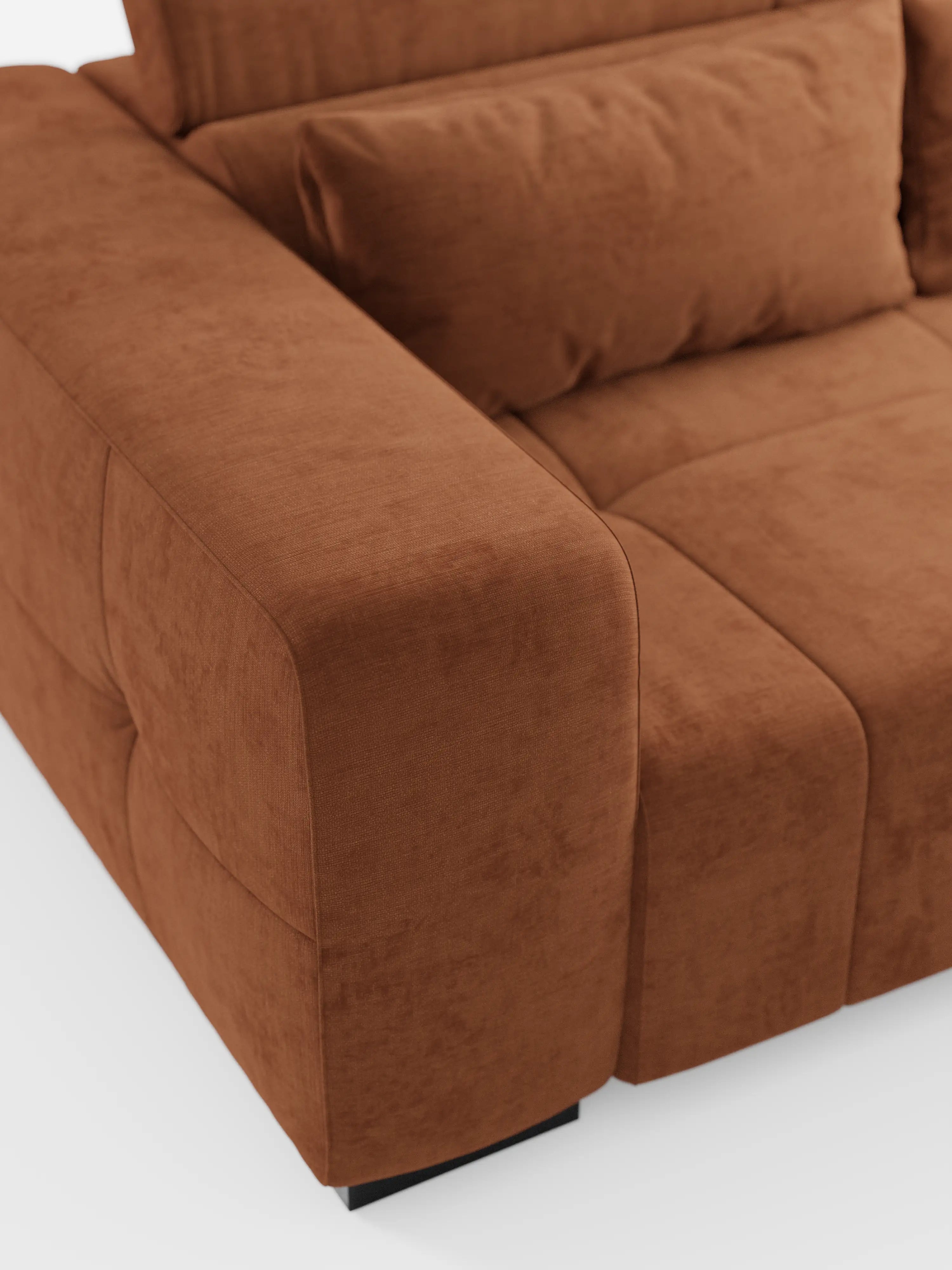 Primo piano del divano Monarch con funzione relax elettrica per l’allungamento delle sedute e poggiatesta reclinabile di Divani.Store, caratterizzato da morbidi cuscini e da un ampio bracciolo che mettono in risalto il rivestimento in tessuto T31, morbido, testurizzato e antimacchia. I dettagli visibili degli angoli e delle cuciture sottolineano l’impeccabile maestria artigianale di questo divano contemporaneo. Il divano poggia su bassi piedini rettangolari neri su uno sfondo bianco.