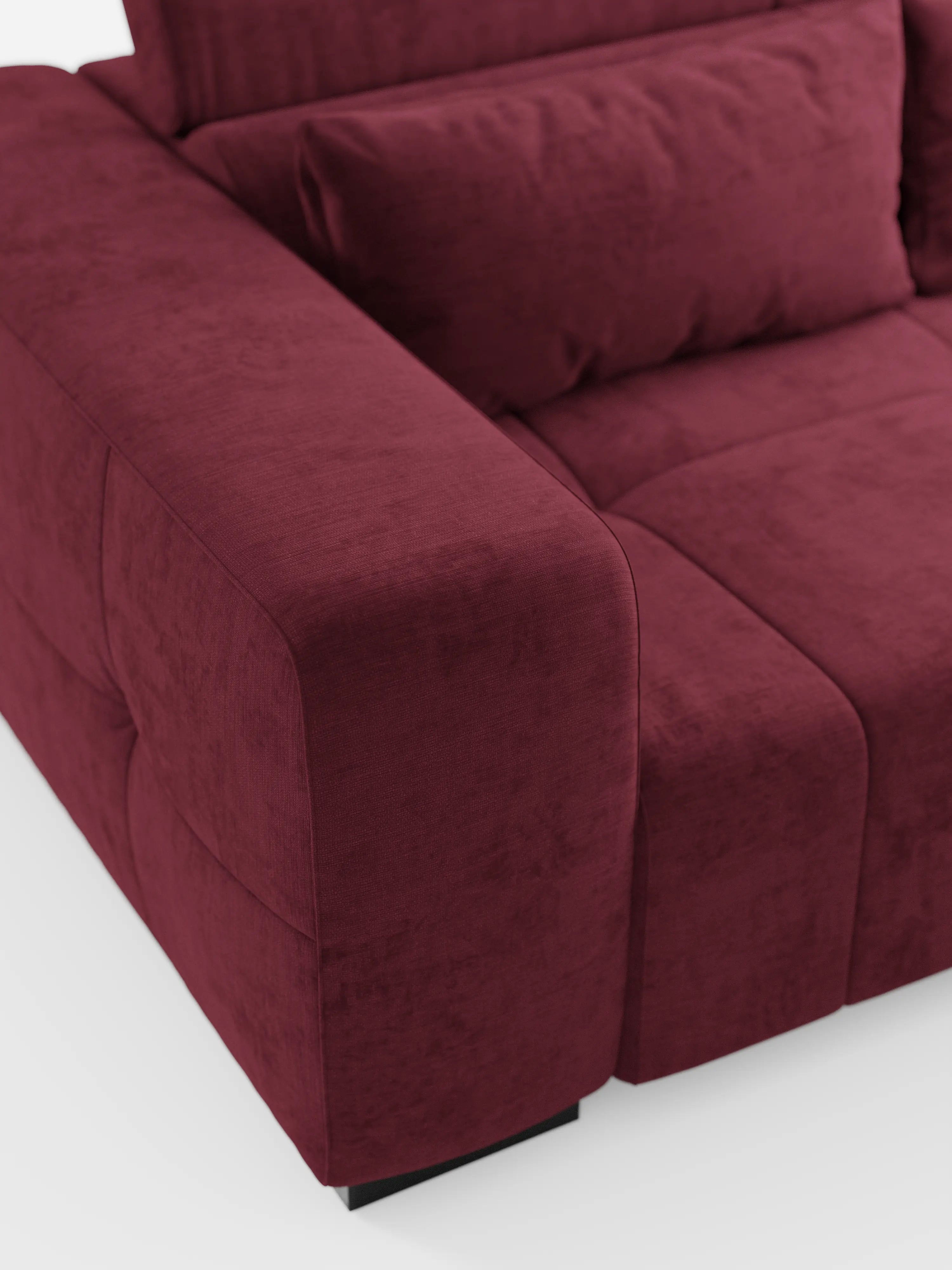 Un primo piano del divano Monarch con funzione relax elettrica per l’allungamento delle sedute e poggiatesta reclinabile, realizzato in morbido tessuto lavabile T31 di Divani.Store. L'immagine mette in risalto l'ampio e morbido bracciolo, la seduta trapuntata e un cuscino dello schienale abbinato. Dotato di un poggiatesta reclinabile per un comfort ancora maggiore, questo moderno divano rosso intenso poggia su brevi gambe nere su uno sfondo bianco, creando un look pulito ed elegante.