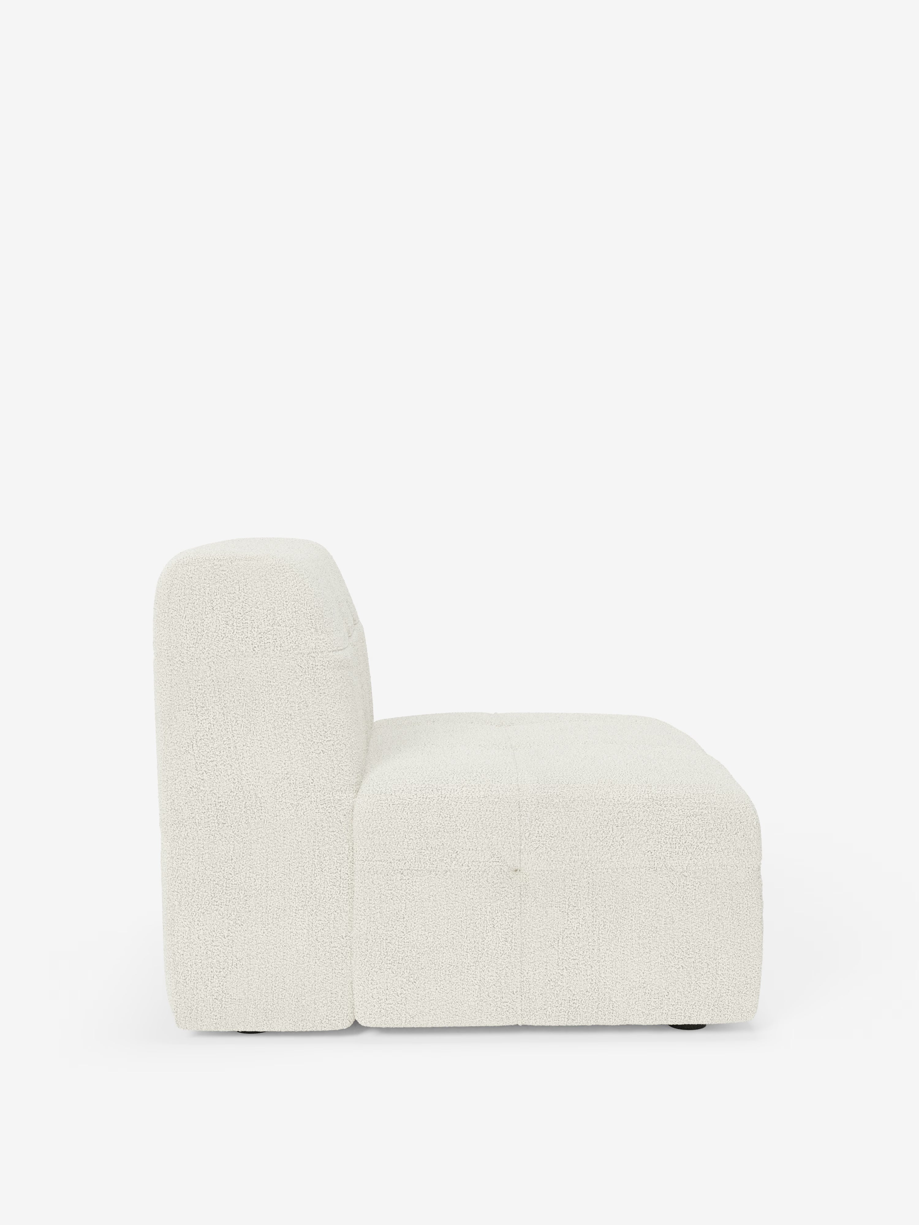 Vista laterale della poltrona modulare Mosaic da 77 cm di Divani.Store, una poltrona modulare senza braccioli rivestita in tessuto bouclé T21 bianco sporco, resistente alle macchie, con dettagli capitonné. La silhouette quadrata, ampia e bassa, presenta uno schienale alto e imbottito, ispirato al design italiano contemporaneo. Su uno sfondo bianco a tinta unita, l’immagine mette in risalto l’estetica minimalista raffinata e la maestria artigianale caratteristiche di questa elegante poltrona Made in Italy.
