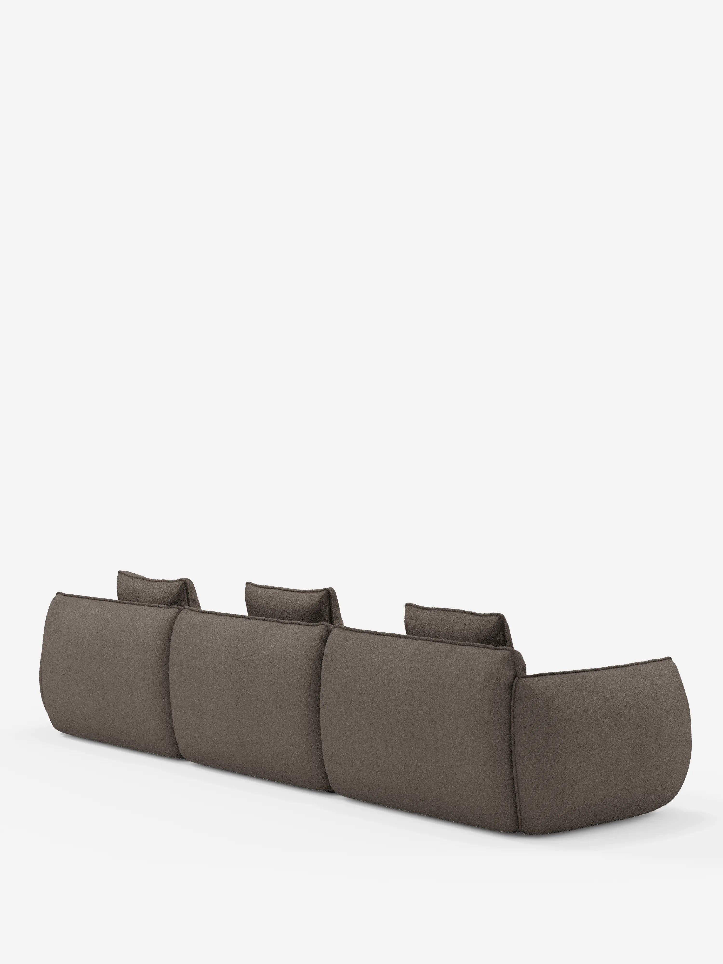 Il divano angolare Nimbus di Divani.Store, con penisola componibile in morbido tessuto effetto cotone smacchiabile T33, è un divano a tre posti dal profilo basso e dal design moderno, ripreso nella vista posteriore su uno sfondo bianco a tinta unita. Ogni seduta è dotata di un cuscino dello schienale separato e il divano presenta bordi morbidi e arrotondati, in un design minimalista e contemporaneo.