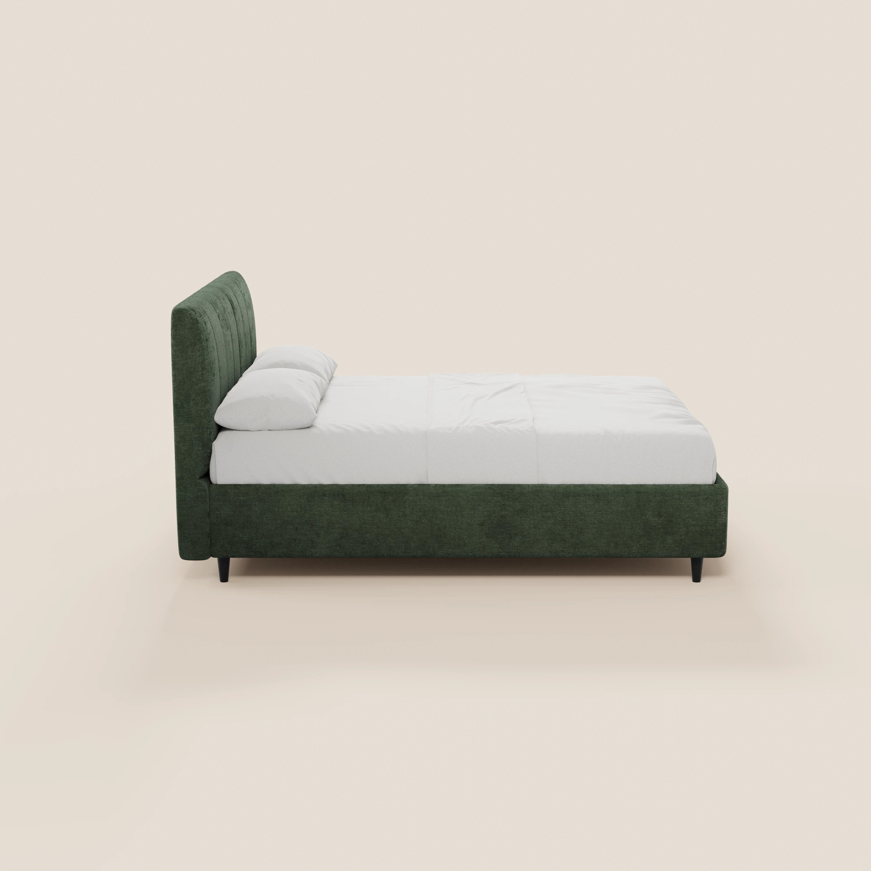 Una vista laterale del letto imbottito ONYX di Letti.store, caratterizzato da una testiera verticale e da una struttura di colore verde scuro, certificate Oeko-Tex®, biancheria da letto bianca con due cuscini e gambe corte nere, il tutto su uno sfondo beige chiaro a tinta unita.