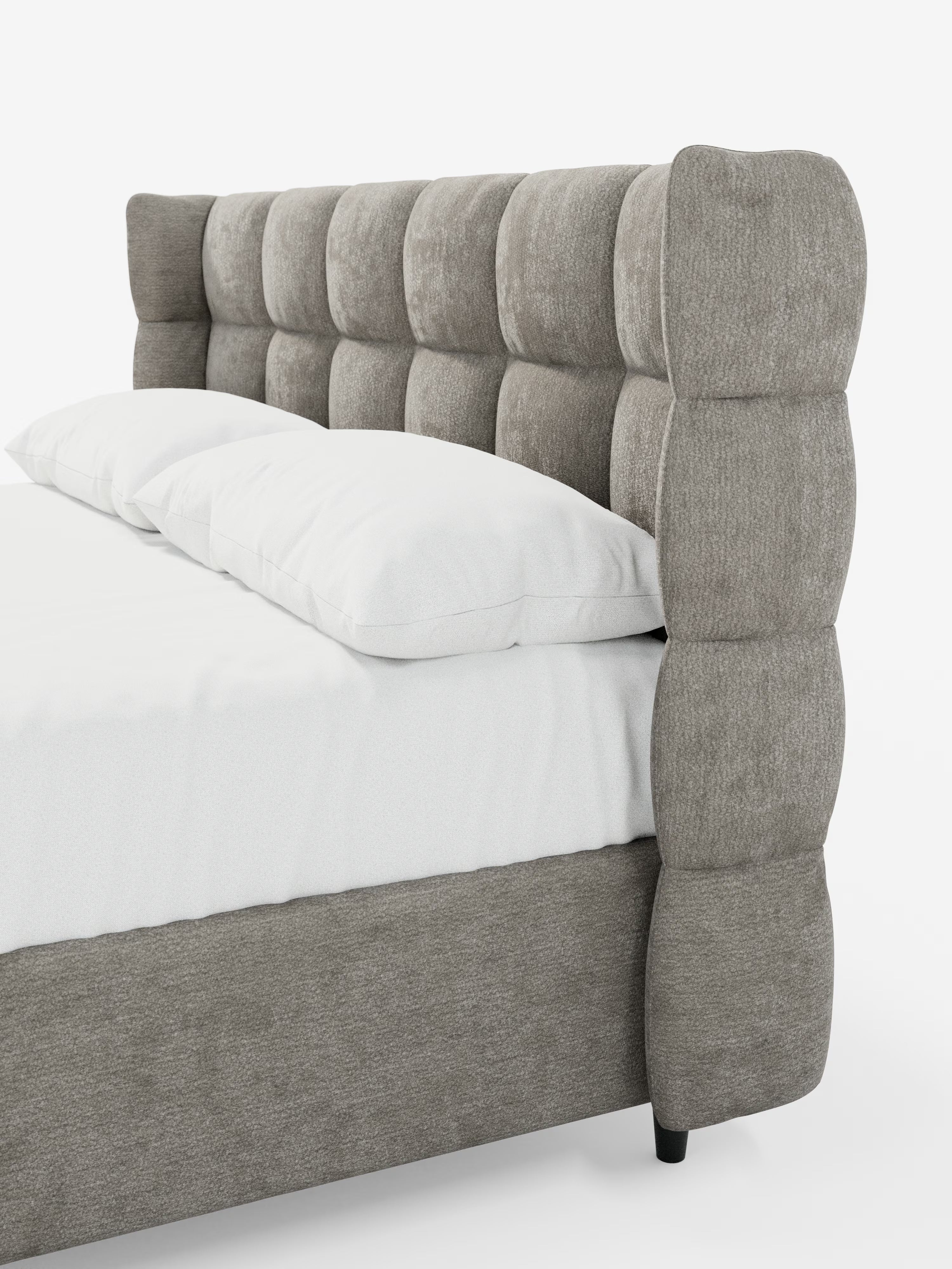 Il letto imbottito RAGNAR con contenitore e testiera capitonné avvolgente di Letti.store presenta un’elegante e morbida testiera grigia con grandi cuscini quadrati trapuntati in un delicato stile capitonné. Rivestito in tessuto certificato Oeko-Tex®, questo letto moderno ha una base grigia abbinata ed è raffigurato con un lenzuolo bianco e due cuscini bianchi su uno sfondo bianco a tinta unita.