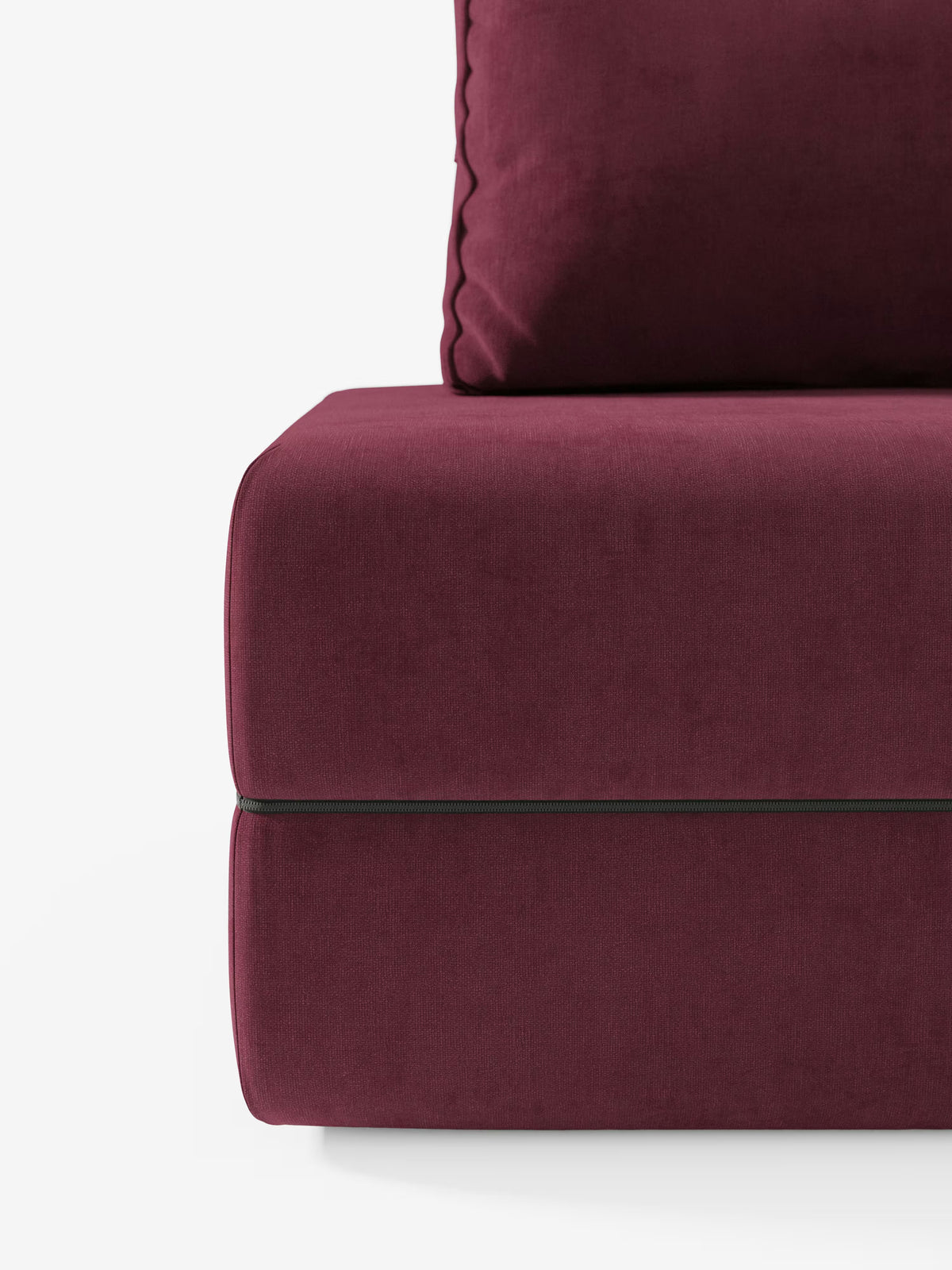 Primo piano della poltrona letto Rift con materasso alto 24 cm e memory foam di Divani.Store, che mette in risalto il rivestimento in tessuto T31 color bordeaux scuro, antimacchia, con cuciture a vista e raffinati dettagli di bordatura. L'immagine mette in risalto la consistenza morbida e vellutata della seduta e una parte dello schienale regolabile su uno sfondo bianco a tinta unita, incarnando l'eleganza moderna e la funzionalità negli interni contemporanei.