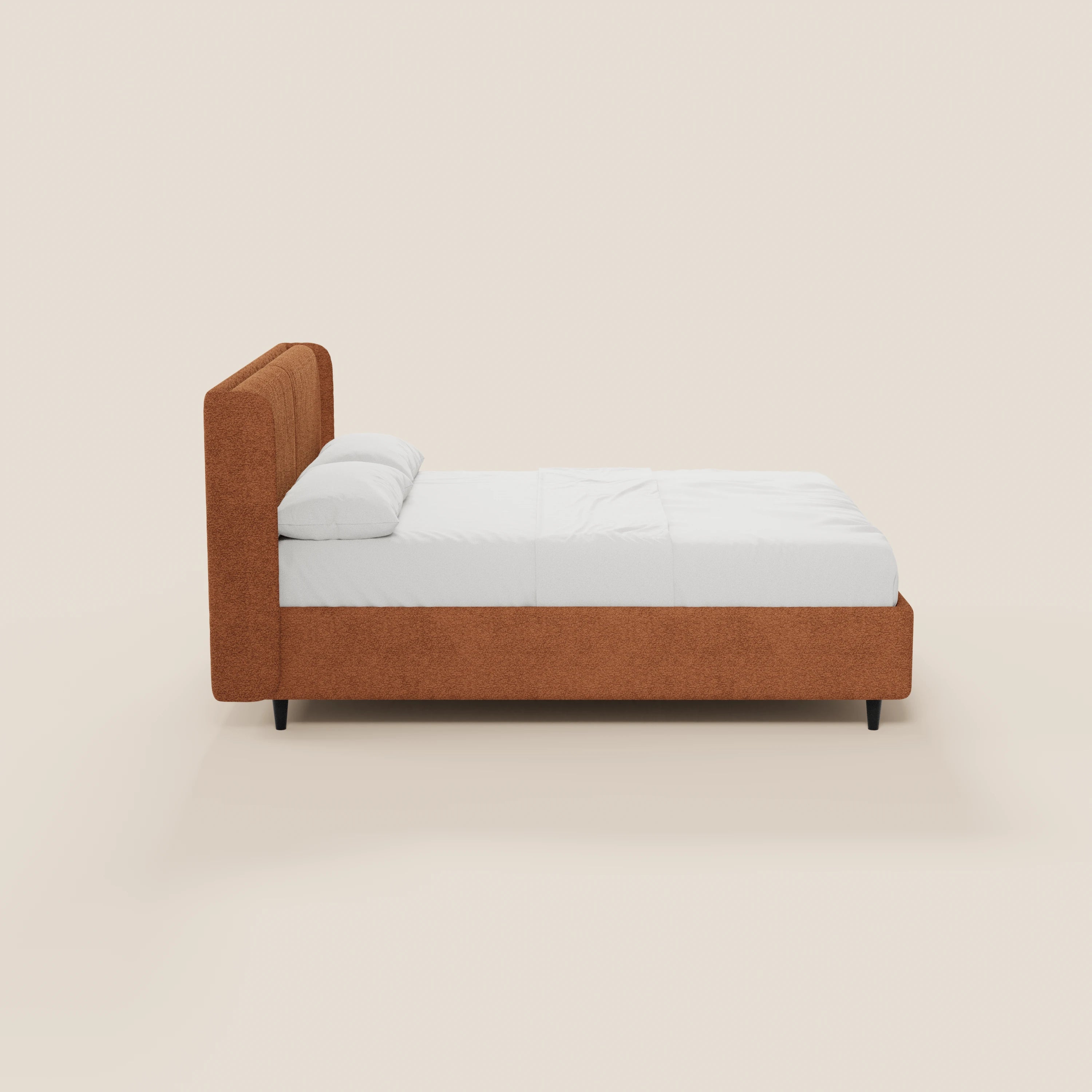 Vista laterale del letto di design VALKIRIA di Letti.store, caratterizzato da una struttura imbottita marrone certificata Oeko-Tex®, testiera avvolgente e 2 cuscini imbottiti. Il letto è presentato con lenzuola e cuscini bianchi, gambe corte nere su uno sfondo beige chiaro.