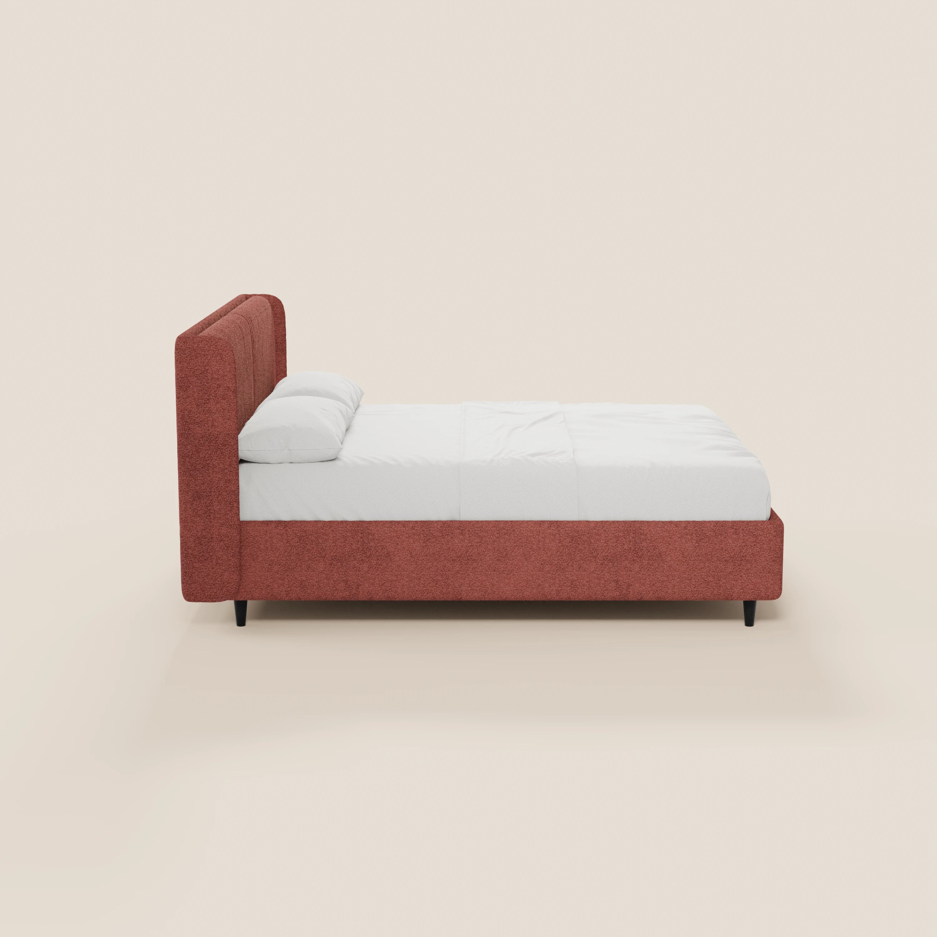 Vista laterale di VALKIRIA, il letto di design di Letti.store con contenitore, testiera avvolgente, 2 cuscini imbottiti certificati Oeko-Tex® e struttura imbottita color ruggine su gambe corte nere, raffigurato con lenzuola bianche su uno sfondo beige chiaro.