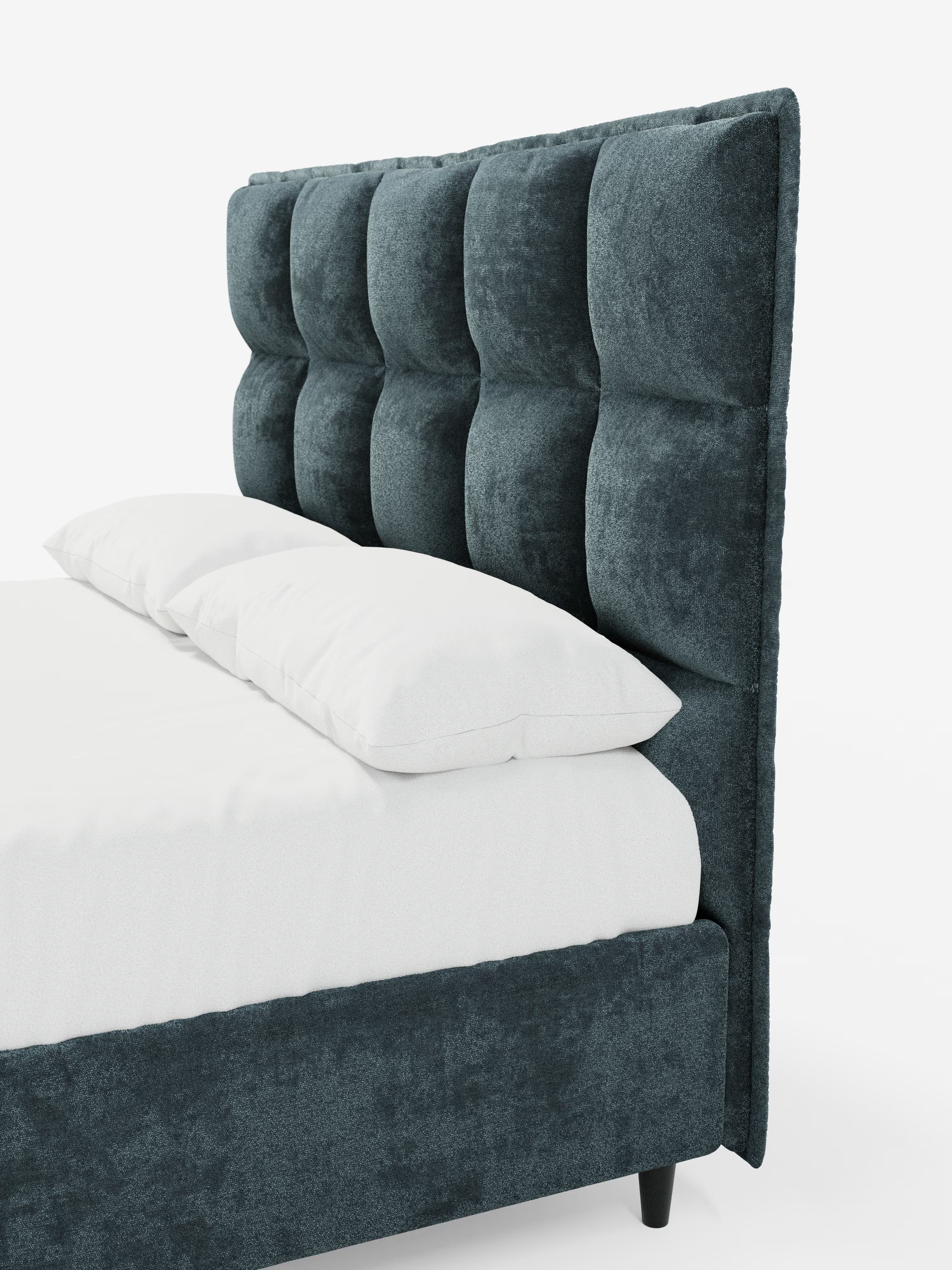 Il letto imbottito AURO con contenitore e testiera alta capitonné in ciniglia Oeko-Tex® di Letti.store presenta una testiera alta capitonné con ampi quadrati imbottiti che conferiscono un tocco di eleganza. Il suo design dal profilo basso è rifinito con un rivestimento in ciniglia coordinato sui lati e raffinate gambe nere. Il letto è impreziosito da due cuscini bianchi e da una biancheria da letto bianca disposta con cura sul materasso.