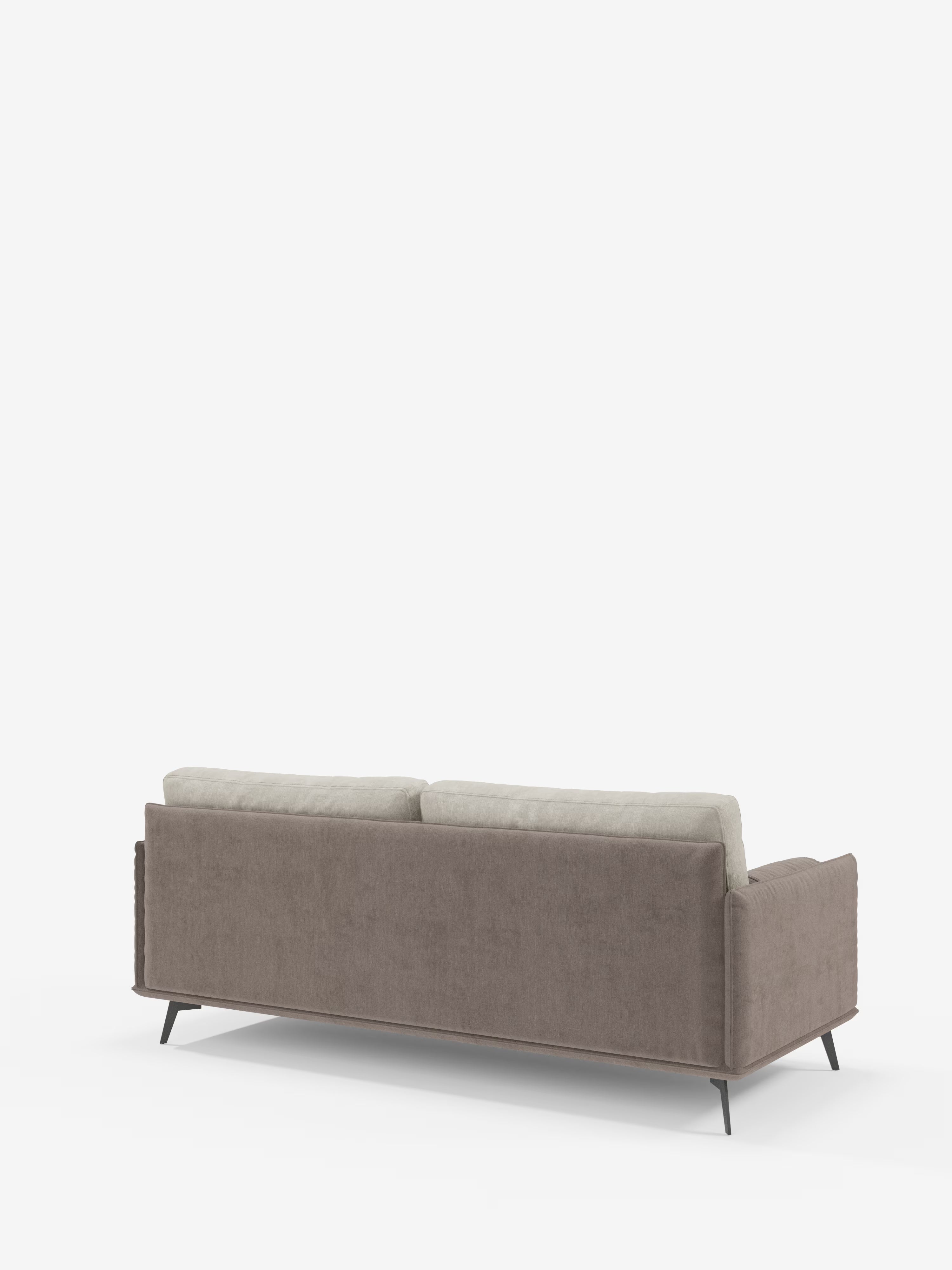 Ecco la frase riscritta utilizzando i dati del prodotto forniti: Un moderno divano Basalto a 2 o 3 posti bicolore di Divani.Store, visto da dietro, presenta cuscini beige chiaro con imbottitura in piuma d’oca, rivestiti in tessuto T31 antimacchia, e una struttura imbottita di colore marrone. Sostenuto da sottili gambe angolate in metallo nero e messo in risalto da uno sfondo bianco, questo divano contemporaneo unisce uno stile sofisticato a un comfort eccezionale.