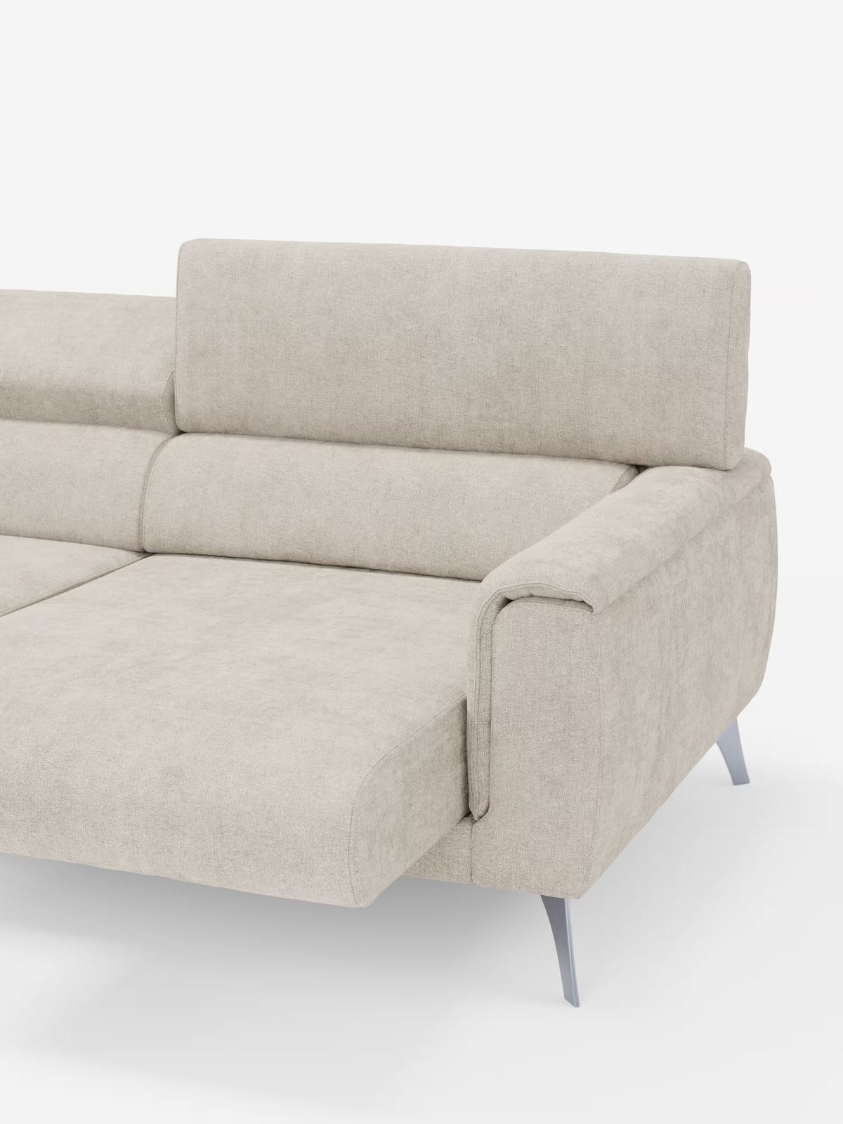 Un elegante divano Caravaggio a 2 e 3 posti di Divani.Store, realizzato in elegante tessuto smacchiabile T31 color beige chiaro, caratterizzato da una silhouette moderna e lineare con bracciolo sul lato destro, schienale basso e sottili gambe in metallo argentato. L’ampio rivestimento in tessuto delle sedute allungabili appare morbido e invitante, offrendo un comfort eccezionale. In primo piano su uno sfondo bianco.