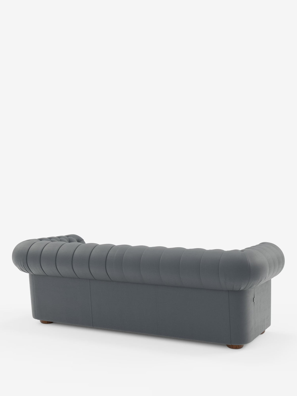 Un divano Chester 4 Posti 3 sedute in vera pelle, colore grigio scuro – Chesterfield Capitonné Artigianale di Divani.Store – è ripreso da dietro in un’angolazione che ne mette in risalto i braccioli arrotondati e lo schienale con l’elegante trapuntatura. Realizzato con maestria in vera pelle, questo divano artigianale poggia su piccole gambe rotonde in legno e si staglia su uno sfondo bianco a tinta unita.