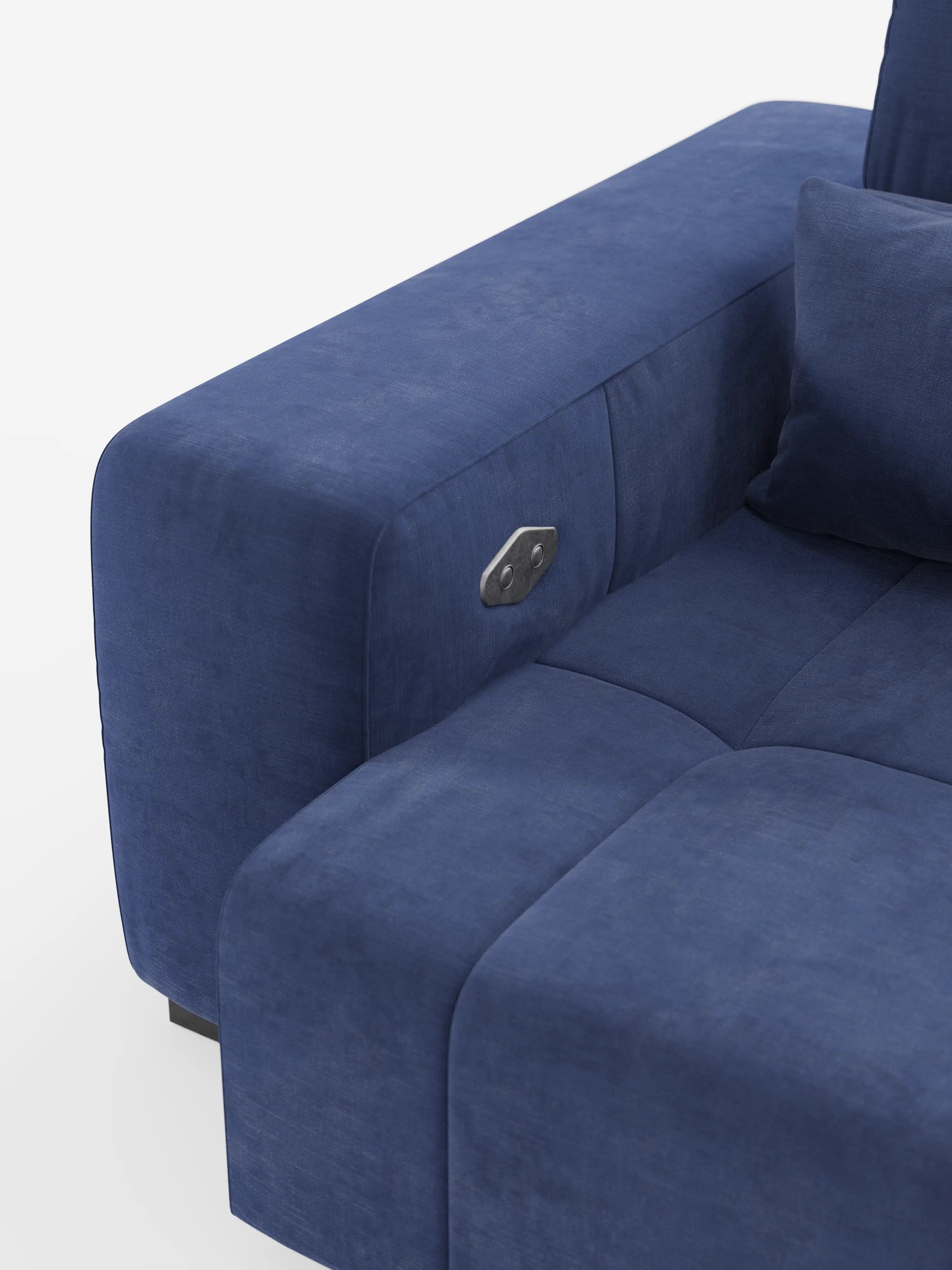 Un primo piano del bracciolo e della seduta del divano Monarch Divano con Relax Elettrico per l’allungamento delle sedute e poggiatesta reclinabile di Divani.Store, realizzato in tessuto blu moderno smacchiabile T31, mostra il pannello dei comandi sul bracciolo, i cuscini soffici e il morbido rivestimento. Lo sfondo bianco mette in risalto il colore intenso e la consistenza liscia del divano.