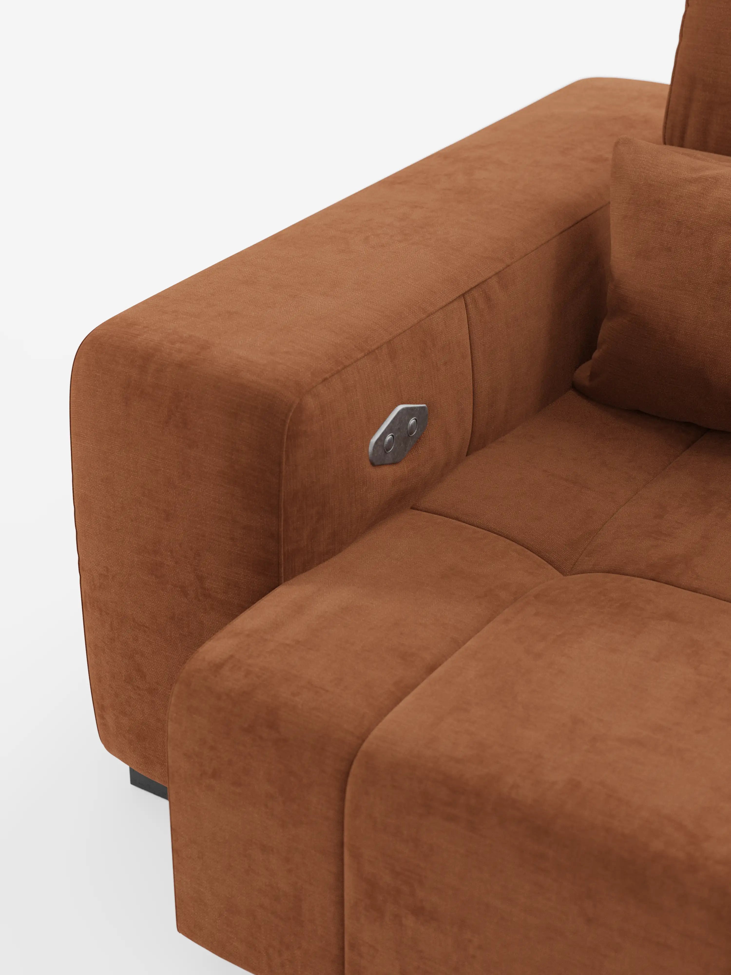 Un primo piano del divano Monarch con funzione relax elettrica per l'allungamento delle sedute e poggiatesta reclinabile in morbido tessuto smacchiabile T31 di Divani.Store mostra il bracciolo sinistro con un pannello di controllo metallico, la seduta imbottita e parte di un cuscino dello schienale, il tutto su uno sfondo bianco.