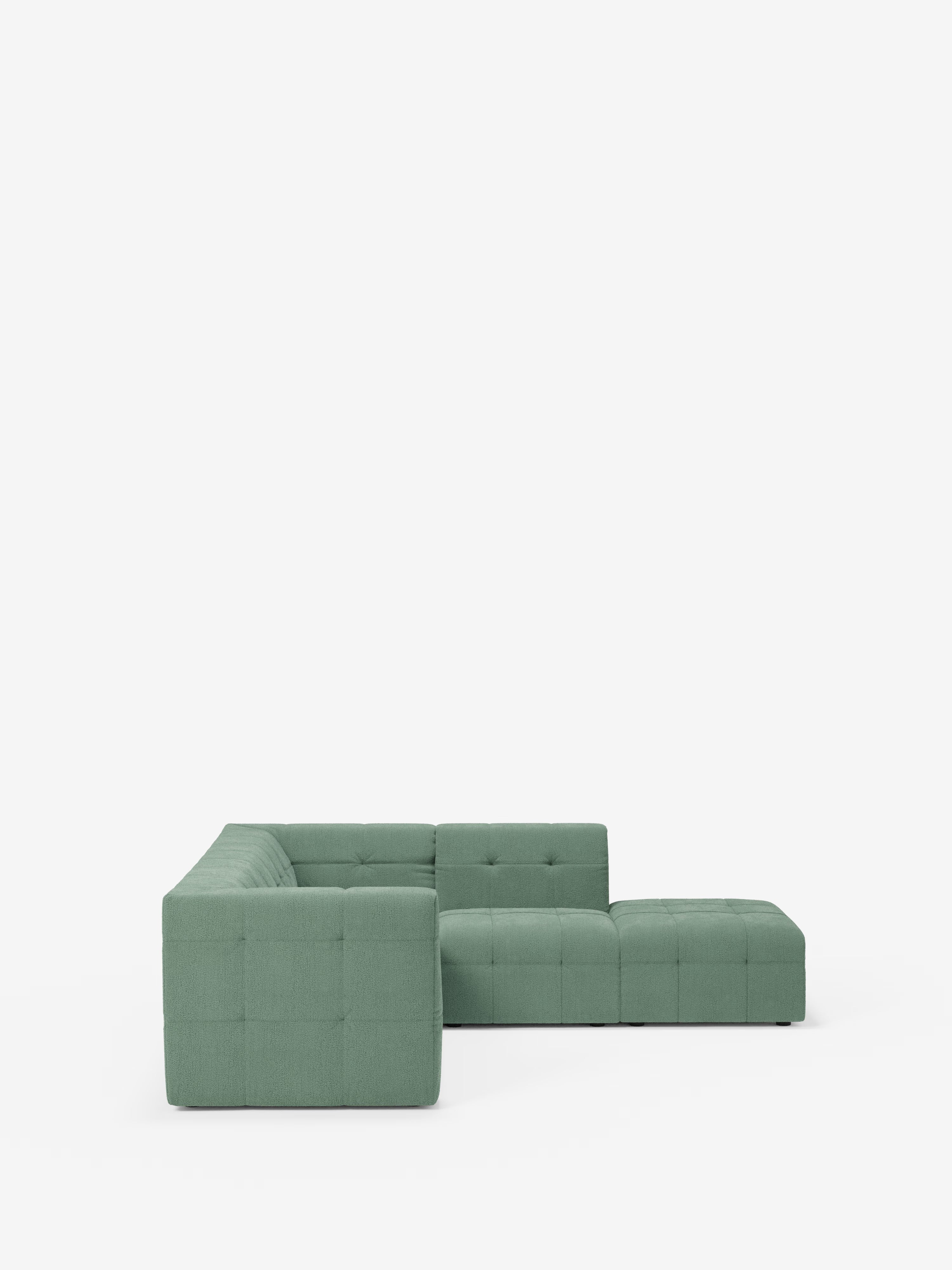 Il divano angolare componibile e modulare Mosaic in bouclé: capitonné e design in tessuto antimacchia T21 di Divani.Store è un divano componibile a forma di L di colore verde, caratterizzato da una silhouette cubica moderna, da un rivestimento capitonné in tessuto bouclé antimacchia e da uno schienale basso. Su uno sfondo bianco a tinta unita, questo divano modulare mette in risalto linee pulite e un comfort accogliente, perfetto per un soggiorno contemporaneo.