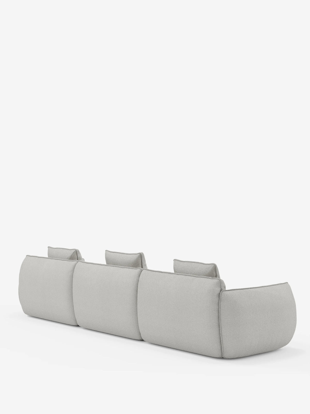 Il divano modulare a 3 posti Nimbus, realizzabile in morbido tessuto smacchiabile effetto cotone T33 di Divani.Store, è ripreso da dietro, mettendo in risalto il suo design moderno in grigio chiaro con angoli arrotondati, ampi braccioli e tre poggiatesta individuali, il tutto su uno sfondo bianco a tinta unita.