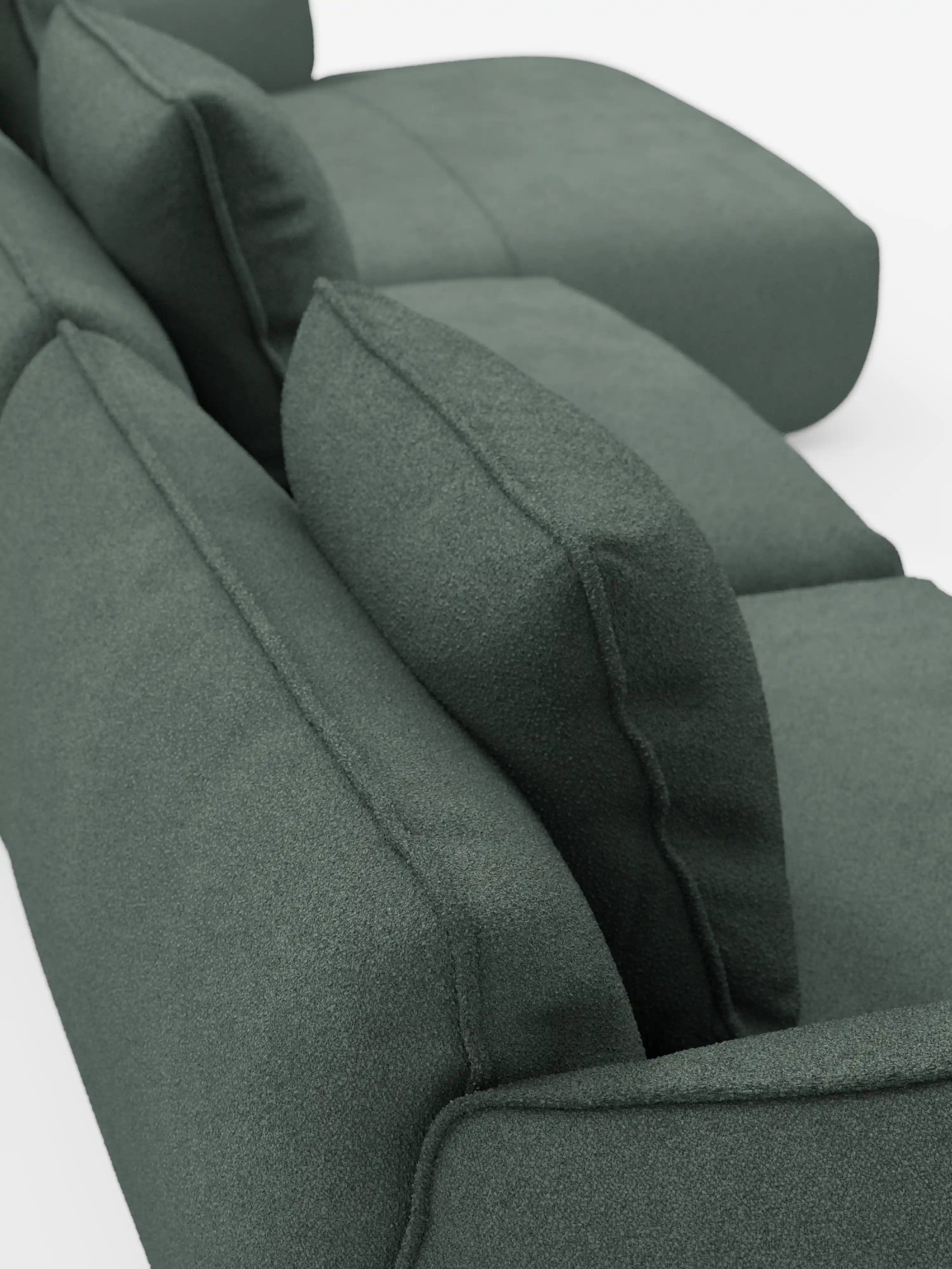 Primo piano del divano angolare con penisola Nimbus di Divani.Store, un divano modulare moderno rivestito in morbido tessuto T33 effetto cotone, resistente alle macchie. L’immagine mette in risalto i cuscini spessi e rettangolari e gli ampi braccioli da un’angolazione che evidenzia la sovrapposizione tra la seduta e lo schienale, sottolineando la consistenza morbida e il design elegante e minimalista su uno sfondo bianco.