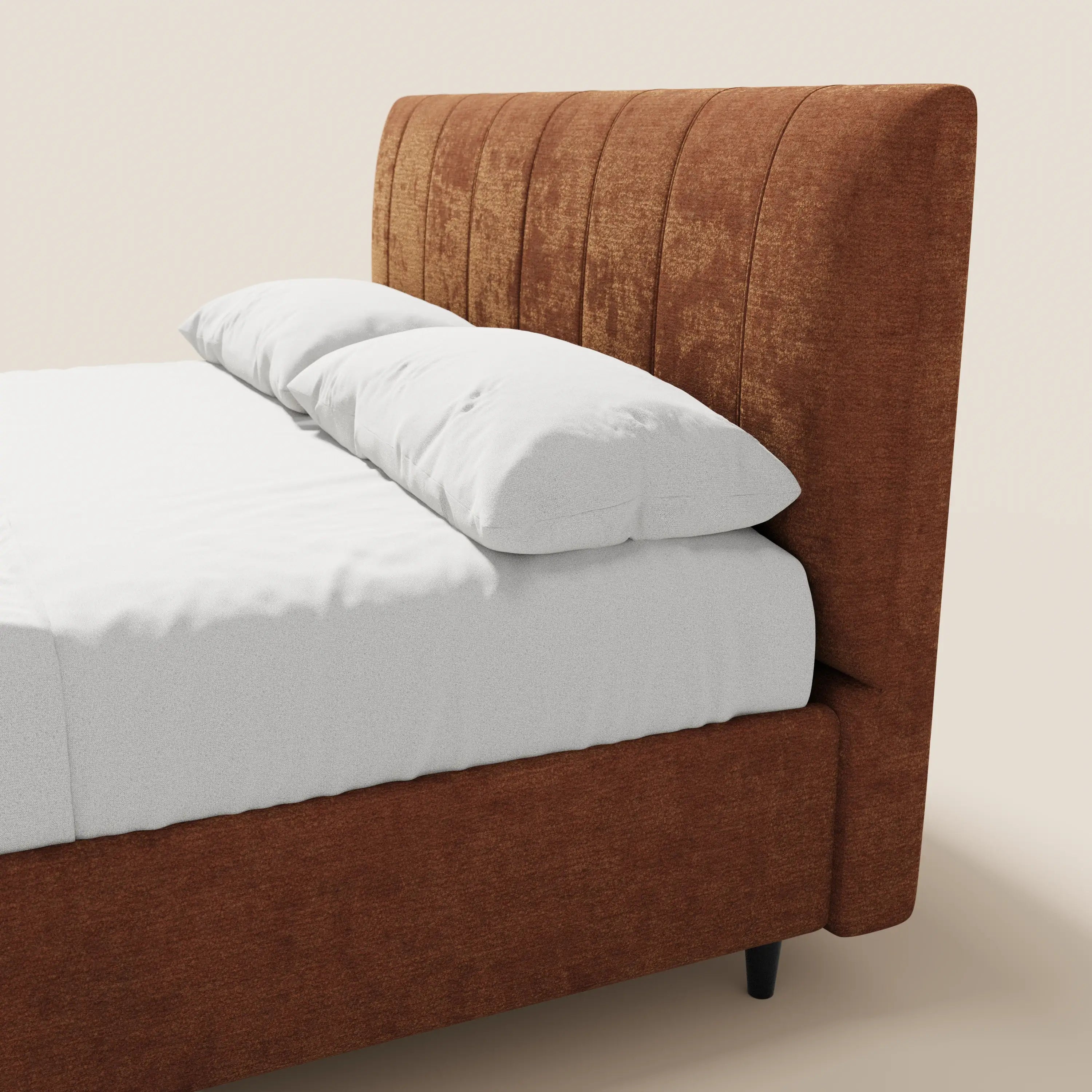 Il letto imbottito ONYX di Letti.store presenta una testiera in tessuto Oeko-Tex® color ruggine a pannelli verticali e una base con contenitore. Allestito con cura con lenzuola e cuscini bianchi, risalta sullo sfondo beige creando un look moderno e accogliente.