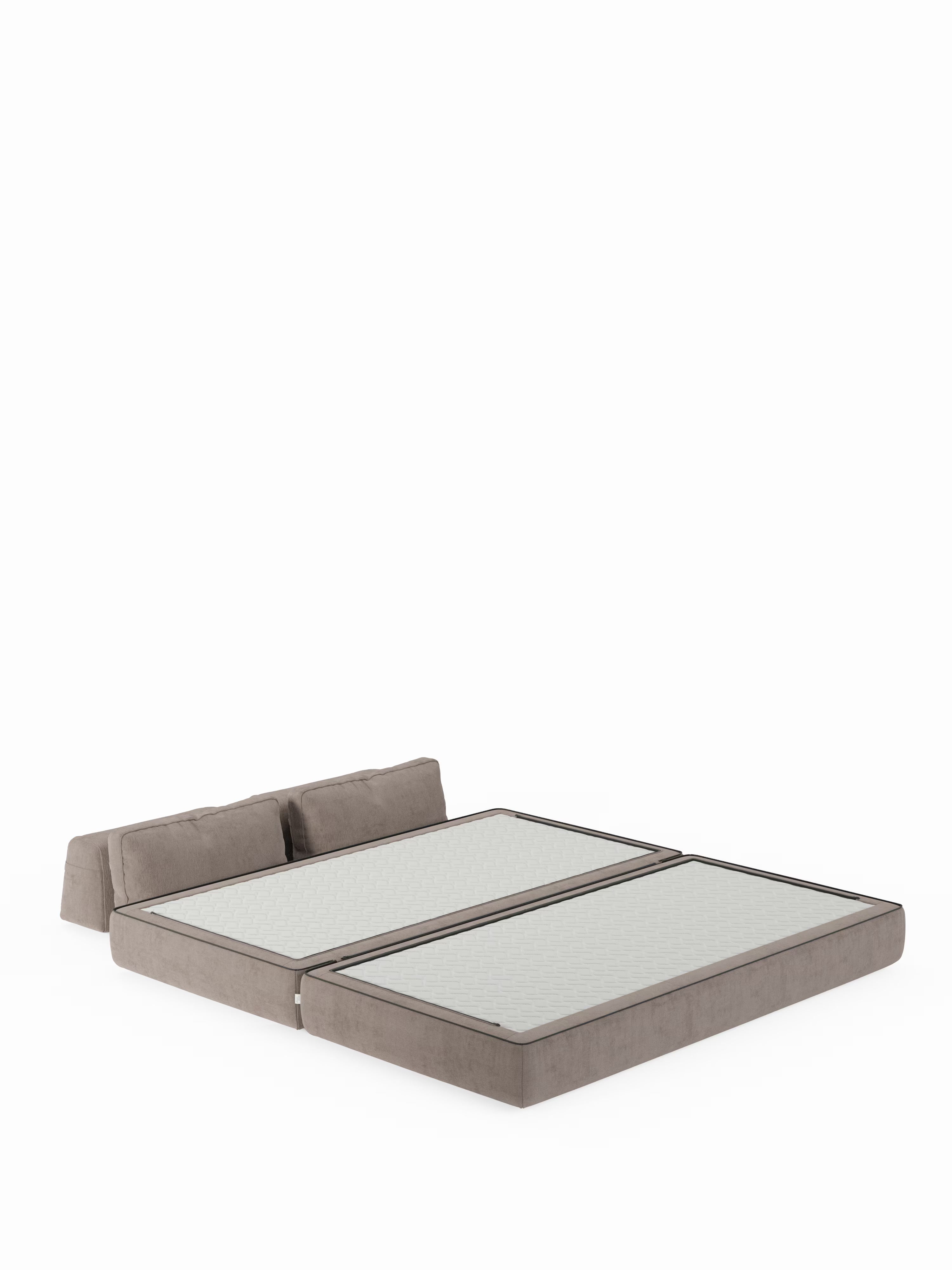 Un divano letto matrimoniale Rift in stile contemporaneo di Divani.Store, caratterizzato da una base imbottita spessa color taupe divisa in due sezioni e da morbidi schienali regolabili per un maggiore comfort, completo di materasso in schiuma memory T31 alto 22 cm. Il letto è raffigurato senza biancheria da letto né cuscini visibili, posizionato su uno sfondo bianco uniforme.