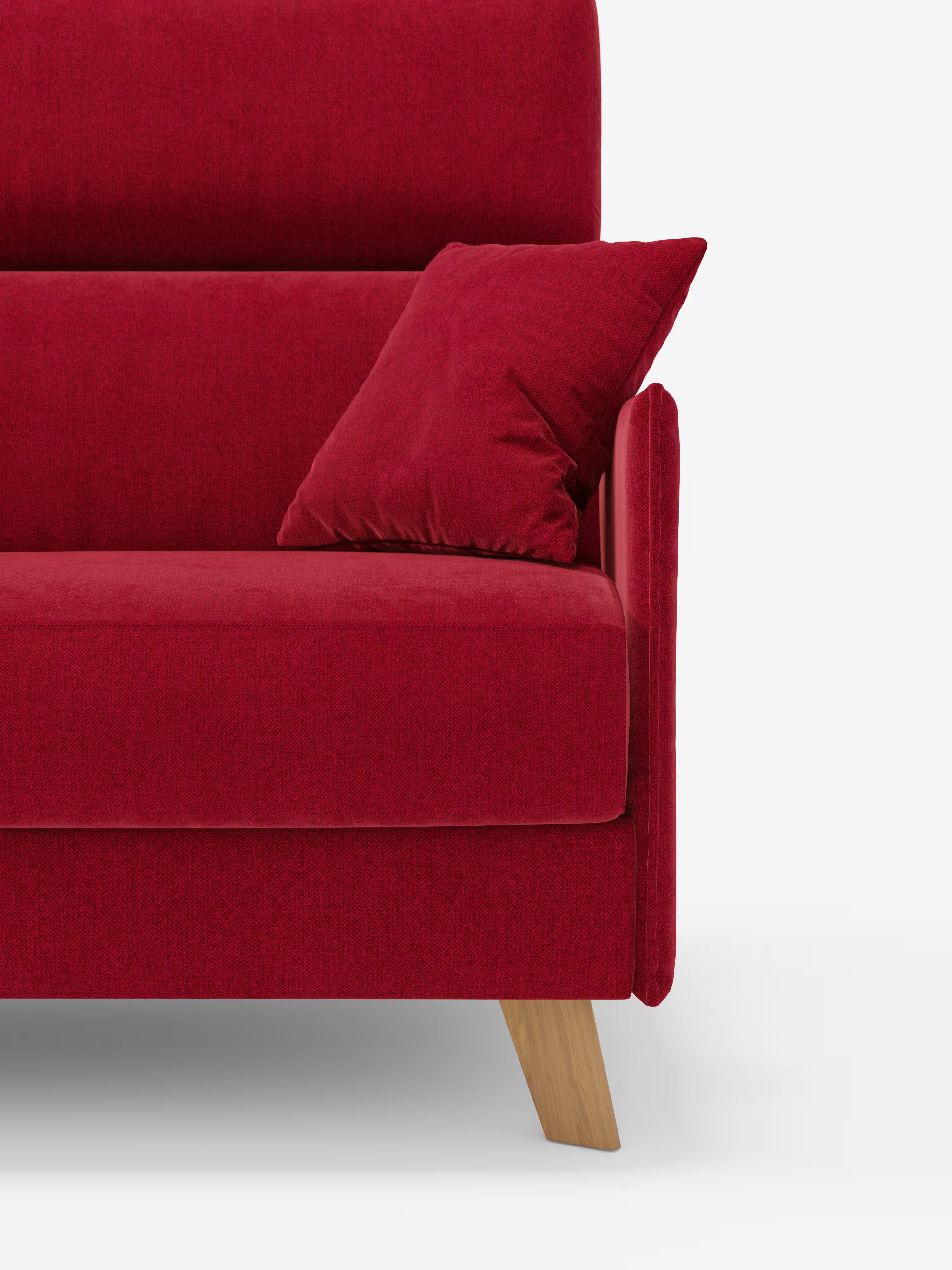 Primo piano del divano letto matrimoniale Sole di Divani.Store, caratterizzato da un moderno rivestimento in tessuto T23 rosso antimacchia, un cuscino coordinato, gambe angolari in legno e linee pulite. La metà sinistra di questo divano di design compatto è raffigurata su uno sfondo bianco, che ne sottolinea il design minimalista di ispirazione scandinava e il fascino vivace. Il modello è dotato di rivestimenti completamente sfoderabili e poggiatesta regolabili per una maggiore funzionalità.