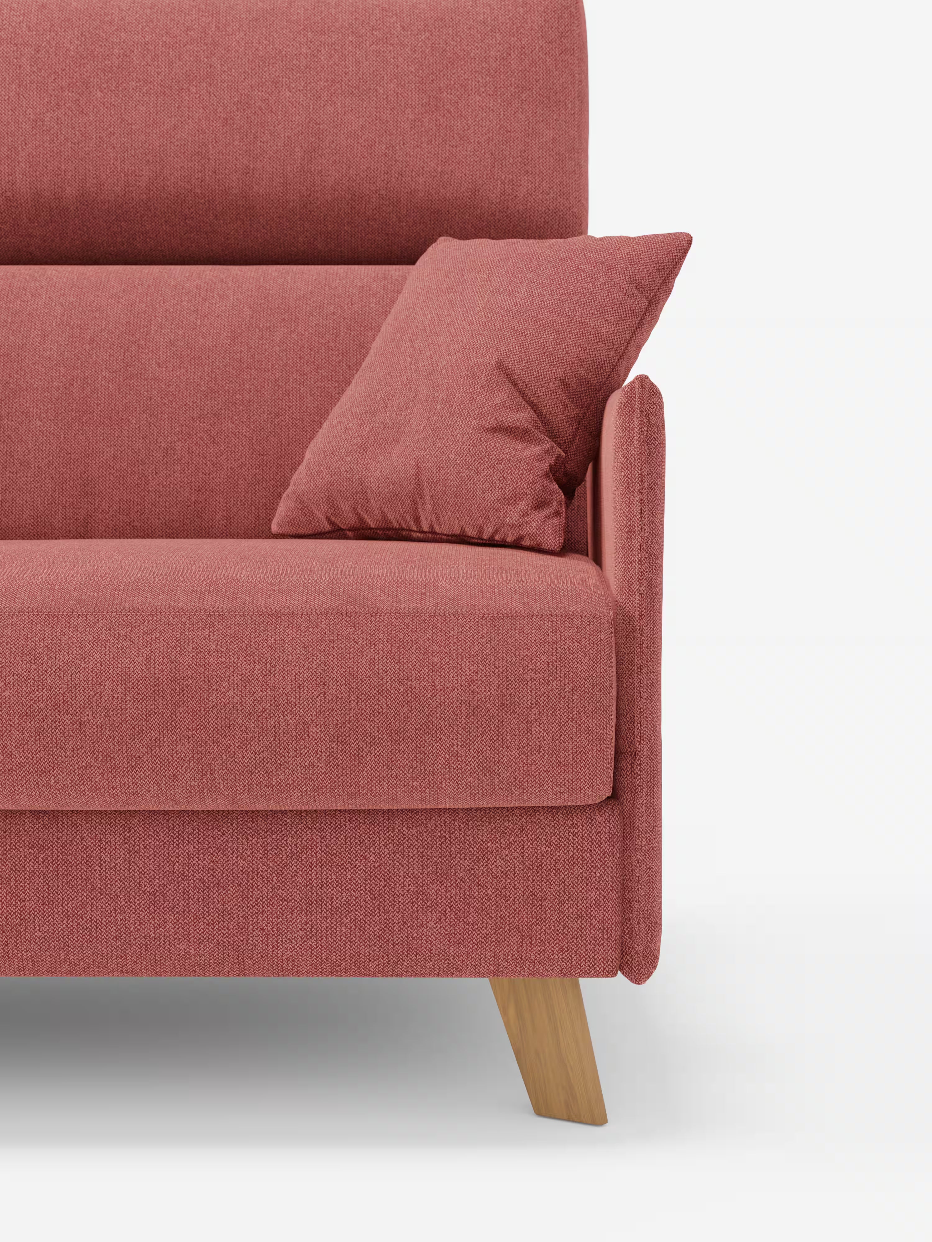 Un primo piano del divano letto matrimoniale Sole dal design compatto di Divani.Store, in una moderna tonalità di rosso rosato, rivestito in tessuto T23 rimovibile al 100% e resistente alle macchie. Il divano in stile scandinavo presenta gambe in legno e include un cuscino coordinato appoggiato al poggiatesta regolabile. Inquadrato su uno sfondo bianco a tinta unita per un look pulito e minimalista, è visibile solo il lato sinistro del divano.