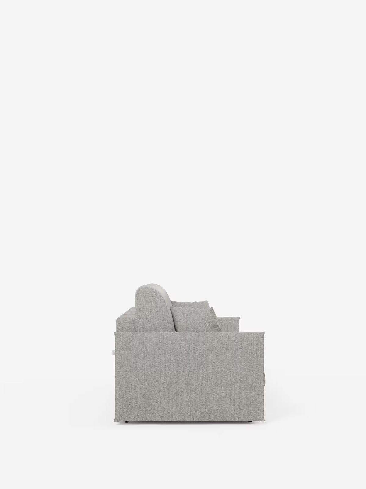 Vista laterale del divano letto matrimoniale sfoderabile Evans di Divani.Store, caratterizzato da un design moderno e compatto con linee dritte e pulite. Rivestito in tessuto T23 facile da pulire, il divano include cuscini di seduta e schienale con un cuscino a vista ed è dotato di un comodo vano porta-cuscini. Lo sfondo bianco e il pavimento in tinta unita mettono in risalto il divano come elemento centrale dell’immagine.