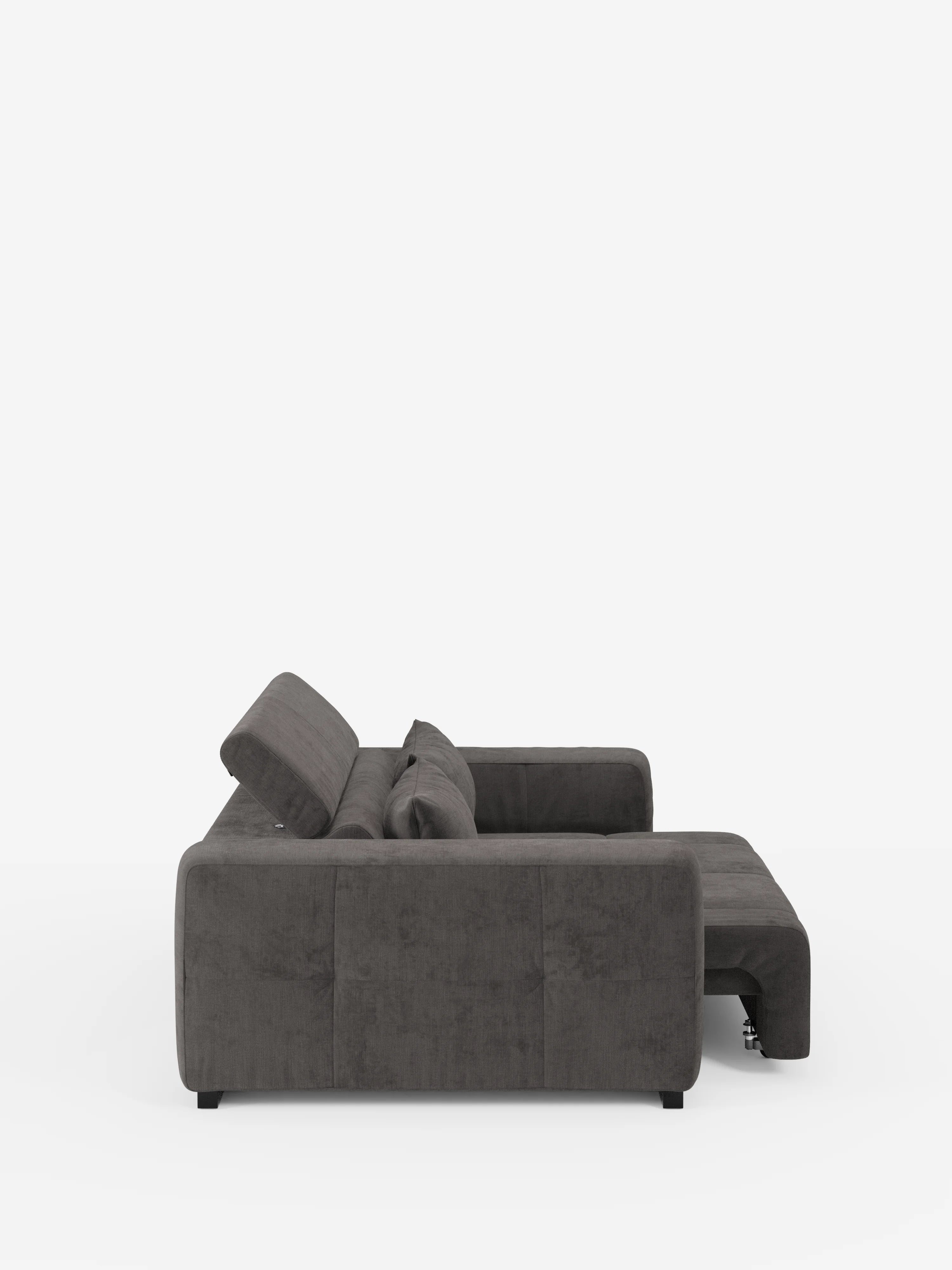 Vista laterale del divano Monarch Divano con Relax Elettrico per l'allungamento delle sedute e poggiatesta reclinabile in morbido tessuto lavabile T31 di Divani.Store: un moderno divano componibile grigio scuro con cuscini soffici, braccioli bassi e squadrati e piedini neri, ripreso su uno sfondo bianco. La chaise longue si estende verso l’esterno e lo schienale su un lato è inclinato per garantire un maggiore comfort.