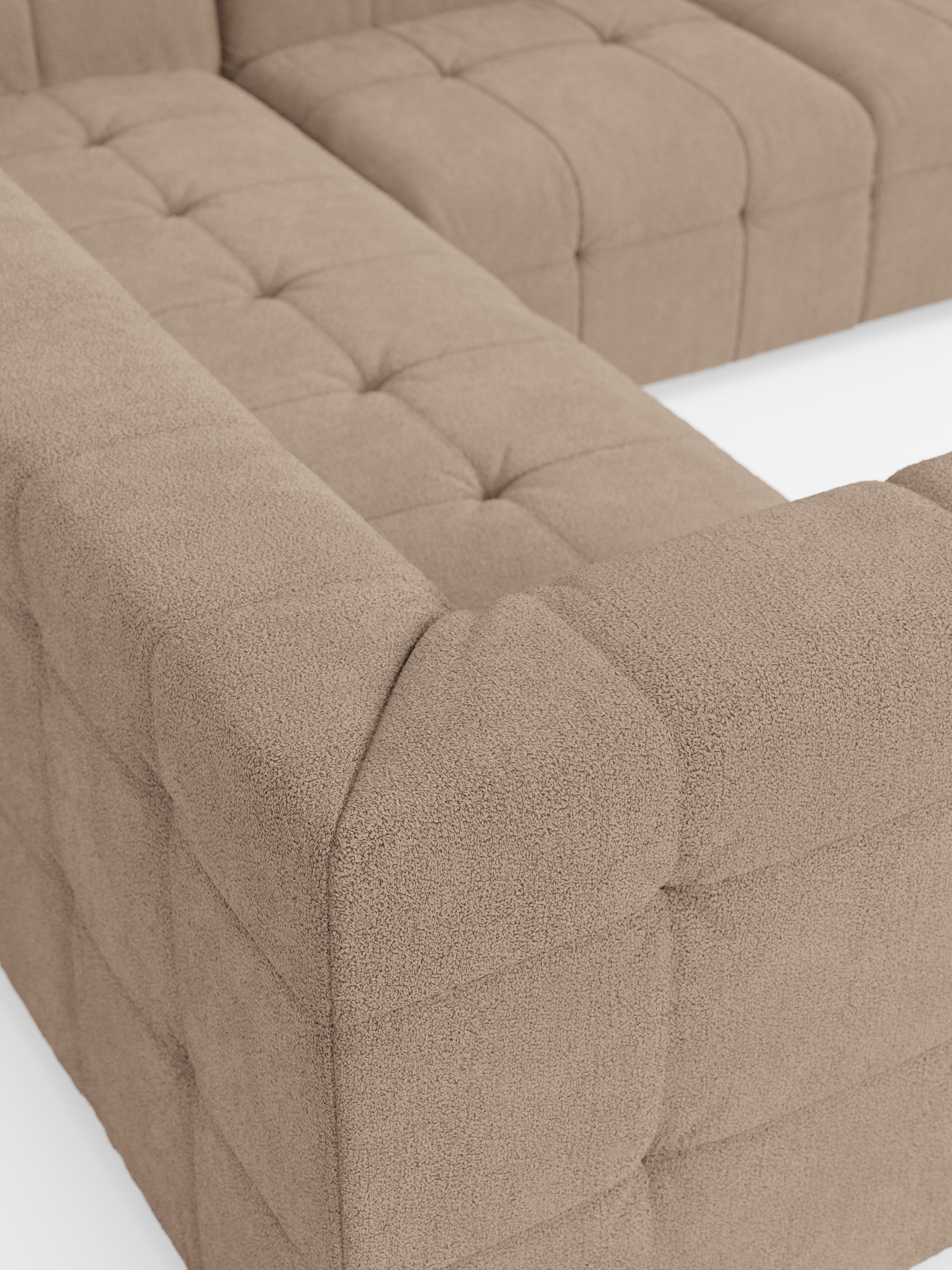 Primo piano del divano angolare componibile e modulare Mosaic in bouclé: capitonné e design in tessuto smacchiabile T21 di Divani.Store, che mette in risalto il rivestimento in bouclé beige testurizzato, le linee pulite e il lussuoso design capitonné su uno sfondo bianco. L’immagine mette in risalto il morbido rivestimento in bouclé, i dettagli delle cuciture elaborate e il look moderno dei braccioli e della seduta del divano.