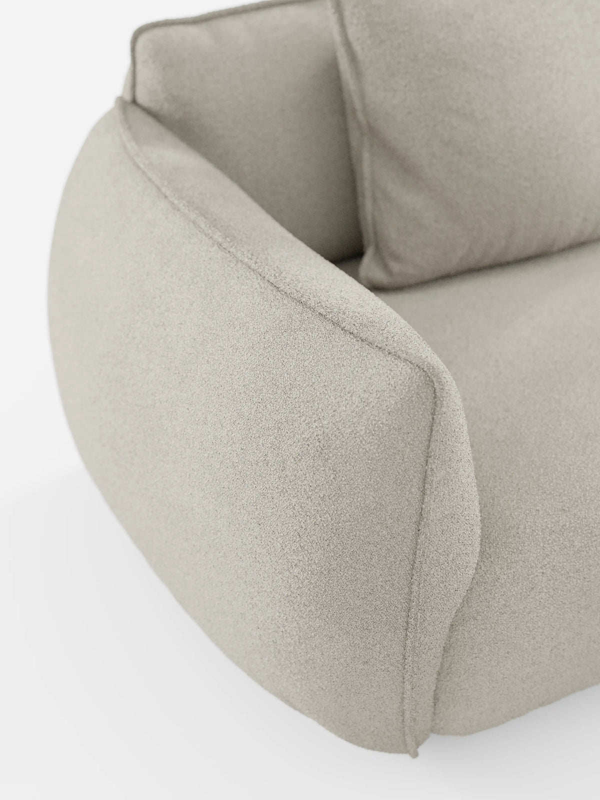 Primo piano del divano modulare a 3 posti “Nimbus” di Divani.Store, rivestito in tessuto T33 effetto cotone, resistente alle macchie, color beige chiaro. L’immagine mette in risalto un bracciolo e parte del cuscino della seduta, evidenziando le forme morbide e arrotondate e il rivestimento soffice tipici di questo divano modulare moderno, su uno sfondo bianco.