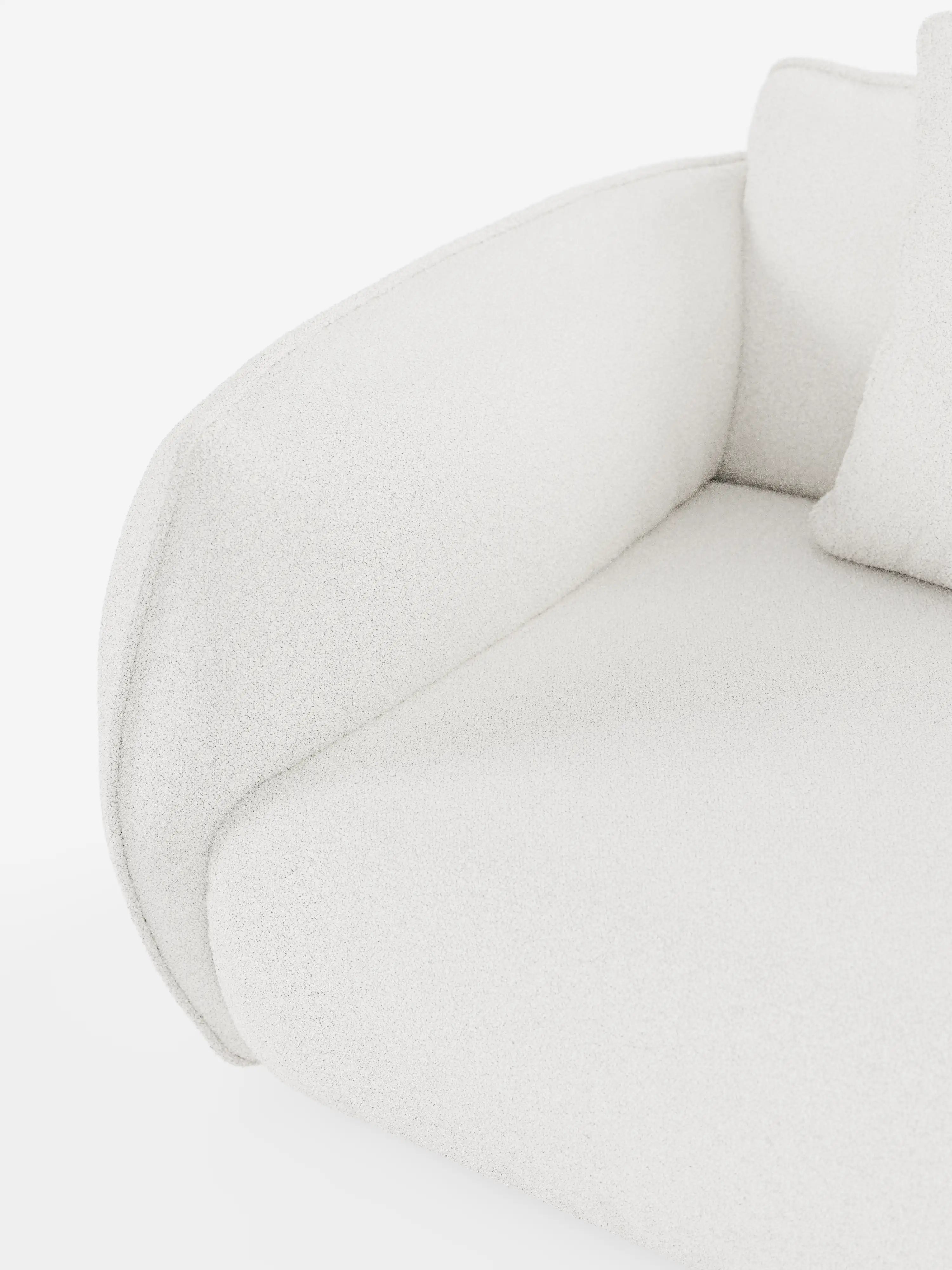 Primo piano del divano angolare con penisola componibile Nimbus in morbido tessuto effetto cotone smacchiabile T33 di Divani.Store, che mette in risalto il suo moderno rivestimento in tessuto bianco, i braccioli arrotondati e il soffice cuscino di seduta con cuscino coordinato. La trama morbida e leggermente felpata risalta sullo sfondo bianco a tinta unita, sottolineando il design pulito e minimalista, perfetto per un divano componibile.