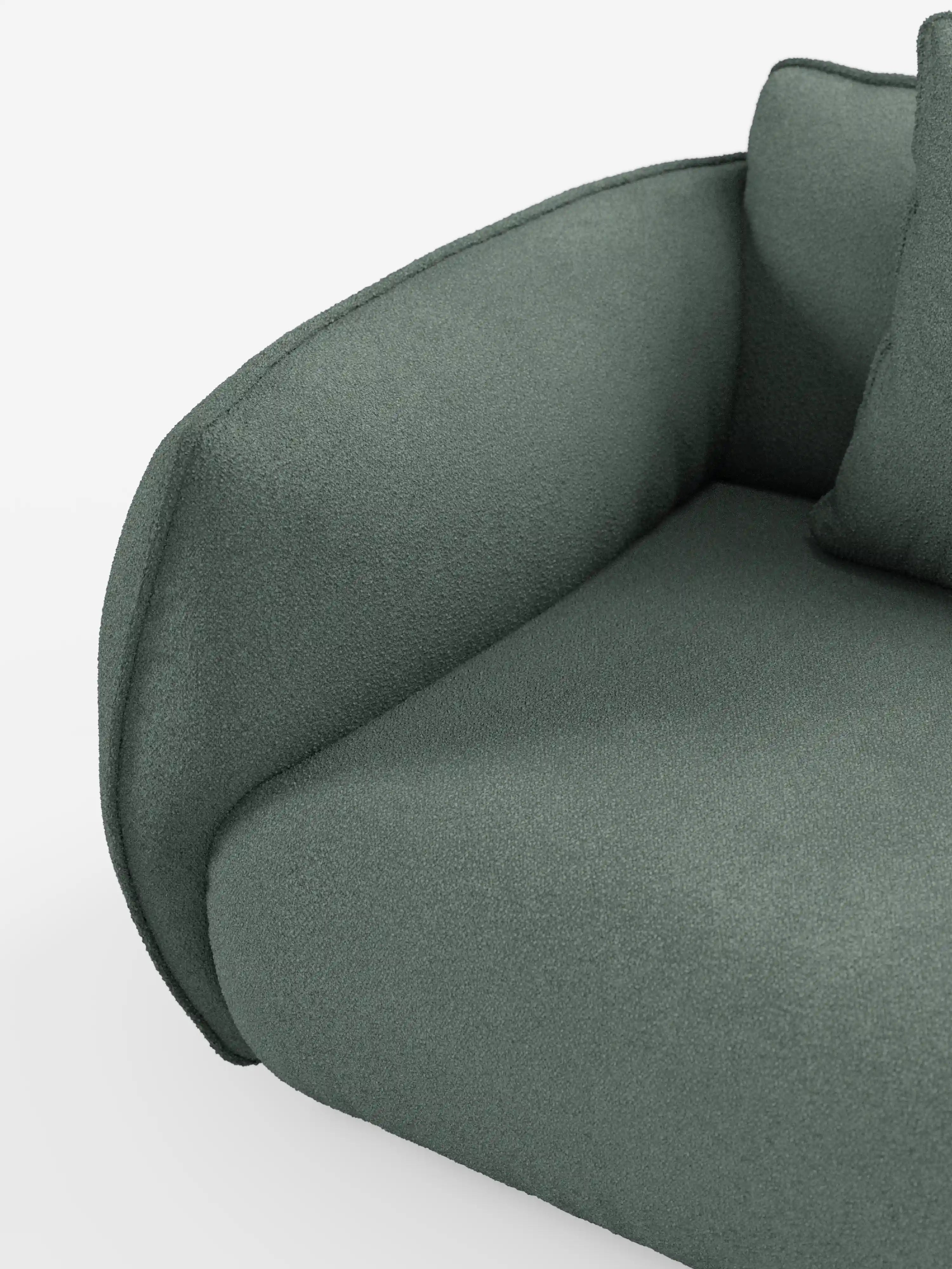 Primo piano del divano angolare Nimbus di Divani.Store con penisola componibile, realizzato in morbido tessuto effetto cotone smacchiabile T33, con particolare attenzione al bracciolo sinistro e al cuscino di seduta rivestiti in verde. Il tessuto effetto cotone appare morbido e materico, con bordi lisci e arrotondati, e un cuscino dello schienale in tinta, parzialmente visibile su uno sfondo bianco a tinta unita.