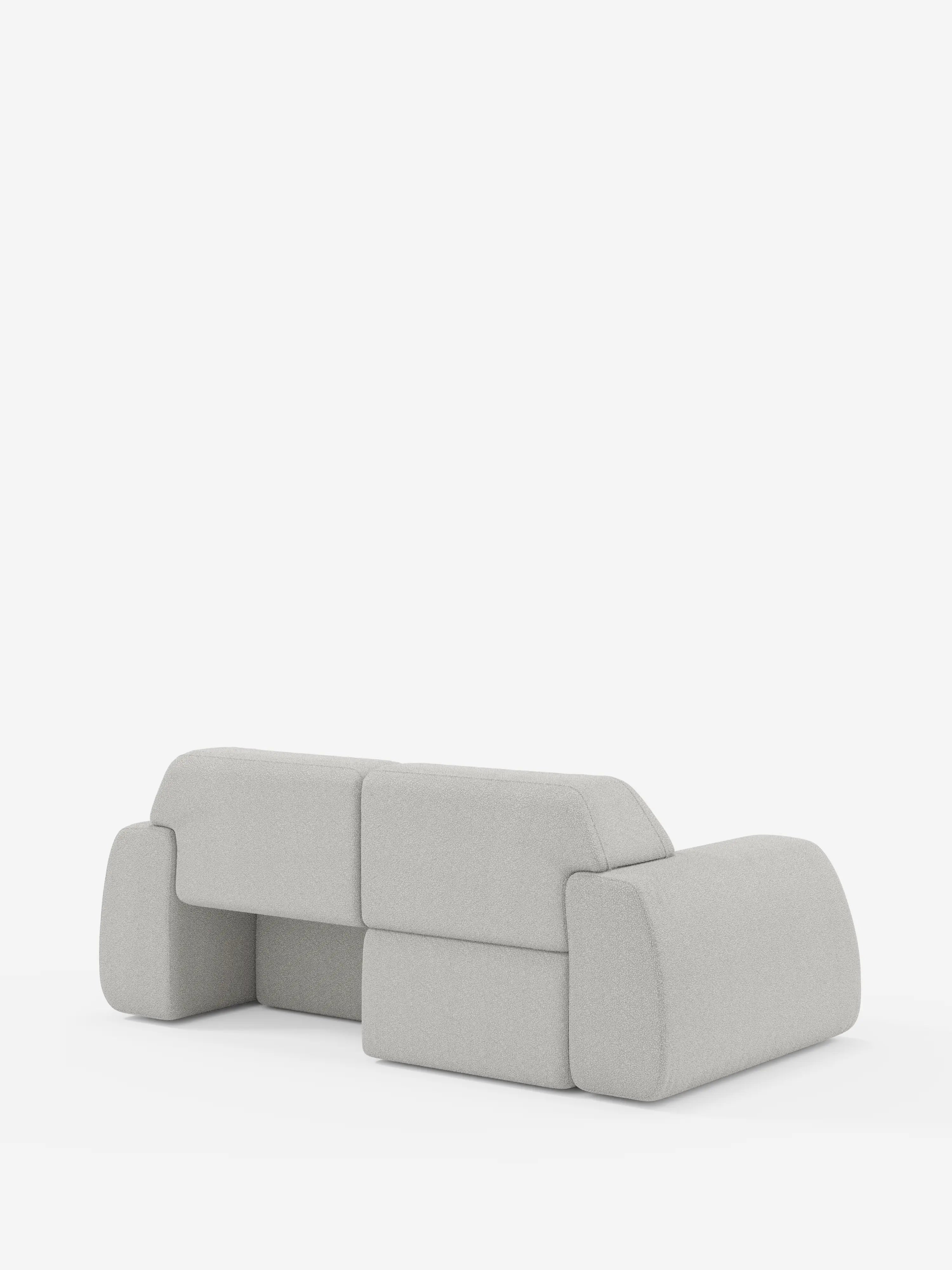 Un divano a 3 posti Orbit di Divani.Store, in grigio chiaro e dal design moderno, caratterizzato da sedute scorrevoli e da una linea bassa e squadrata con bordi arrotondati e senza gambe a vista, è posto su uno sfondo bianco a tinta unita. Sia lo schienale che i braccioli si integrano perfettamente nella sua forma morbida e geometrica, conferendogli un tocco inconfondibilmente contemporaneo. Il divano è completamente sfoderabile e rivestito in tessuto smacchiabile effetto cotone T33.
