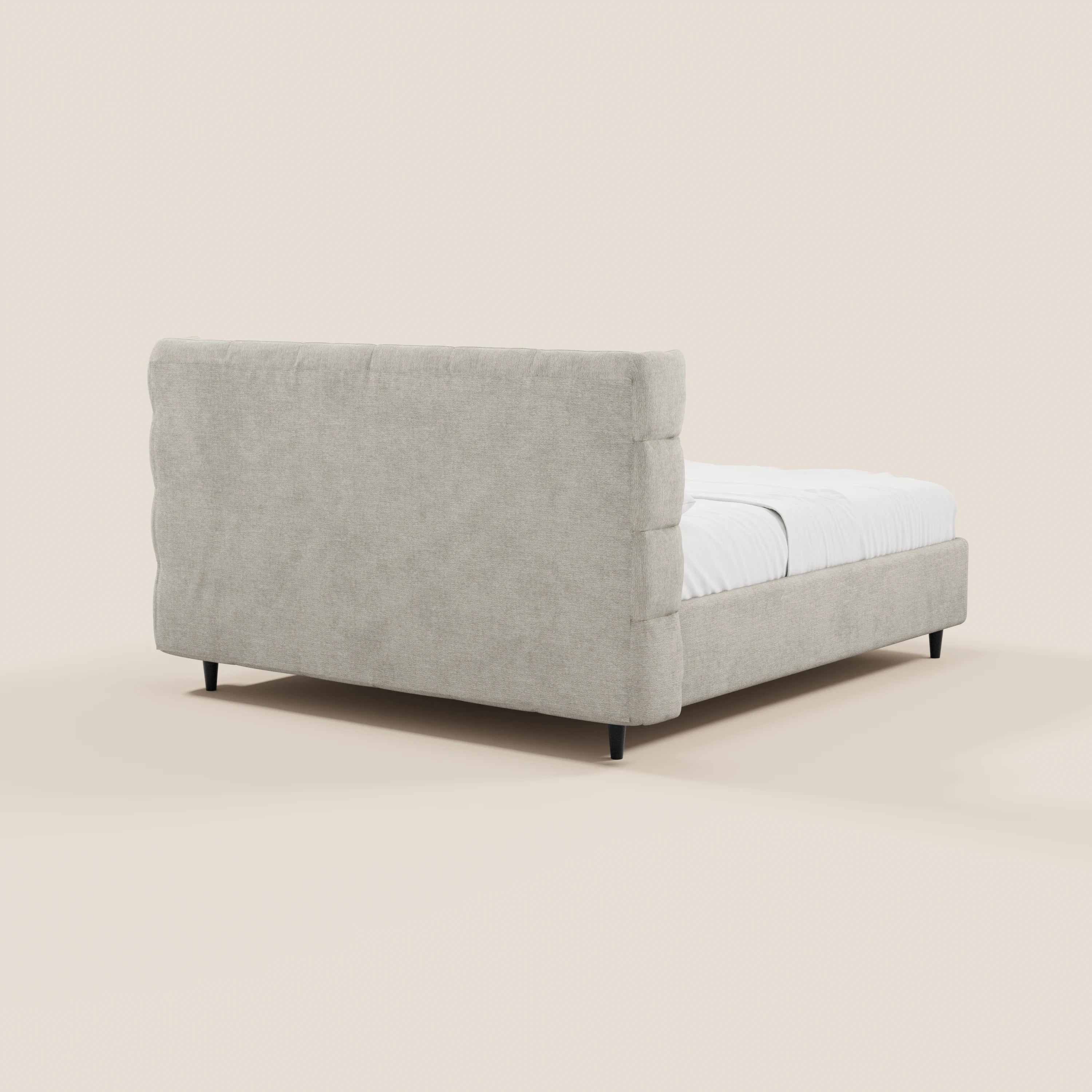 Il letto imbottito RAGNAR di Letti.store presenta una testiera alta e avvolgente con finitura capitonné e una pediera bassa, un elegante tessuto beige certificato Oeko-Tex®, quattro gambe nere e un vano contenitore: perfetto per gli spazi moderni.