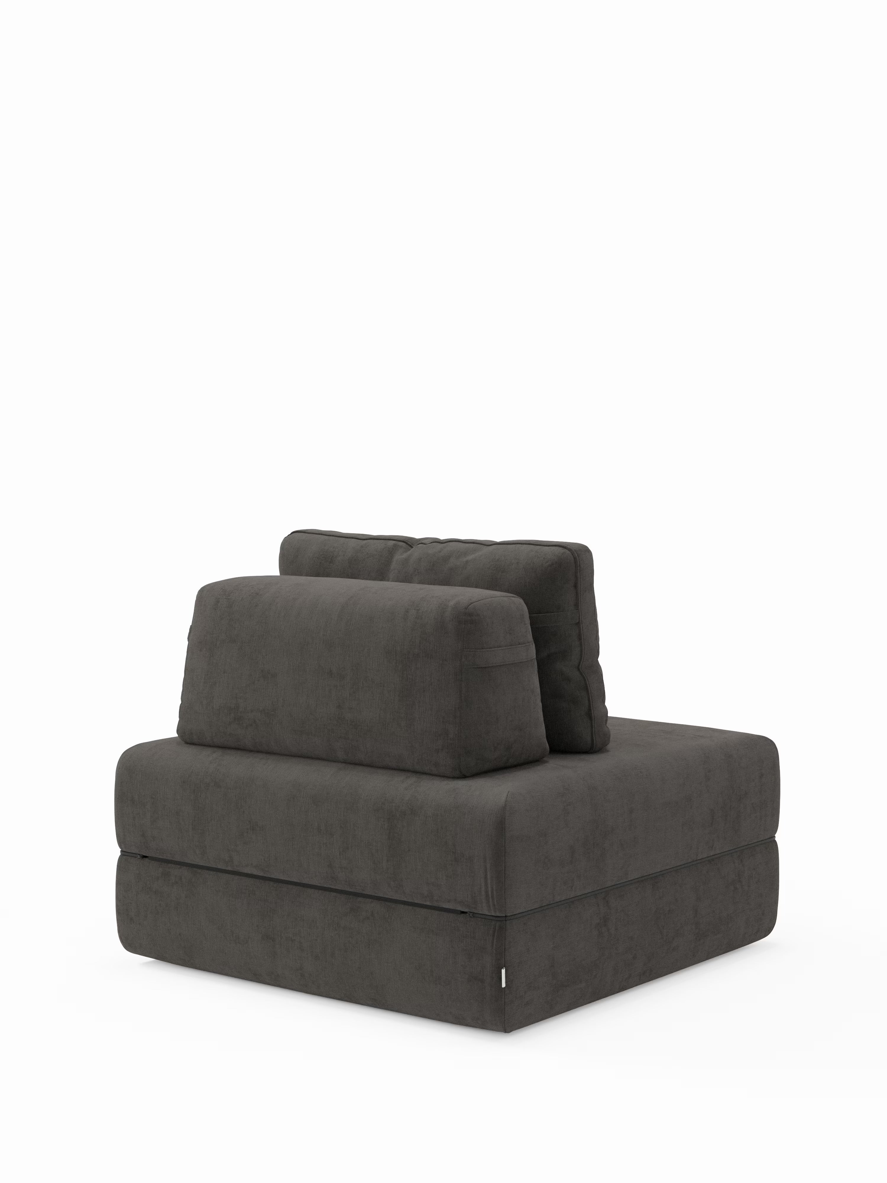 Una poltrona moderna senza braccioli, di colore grigio scuro, con morbidi cuscini e un design squadrato, su uno sfondo bianco a tinta unita. La poltrona letto Rift con materasso alto 22 cm e memory foam di Divani.Store è dotata di schienale regolabile e tessuto T31 resistente alle macchie, e coniuga perfettamente l'estetica minimalista con la praticità, per un look davvero contemporaneo.