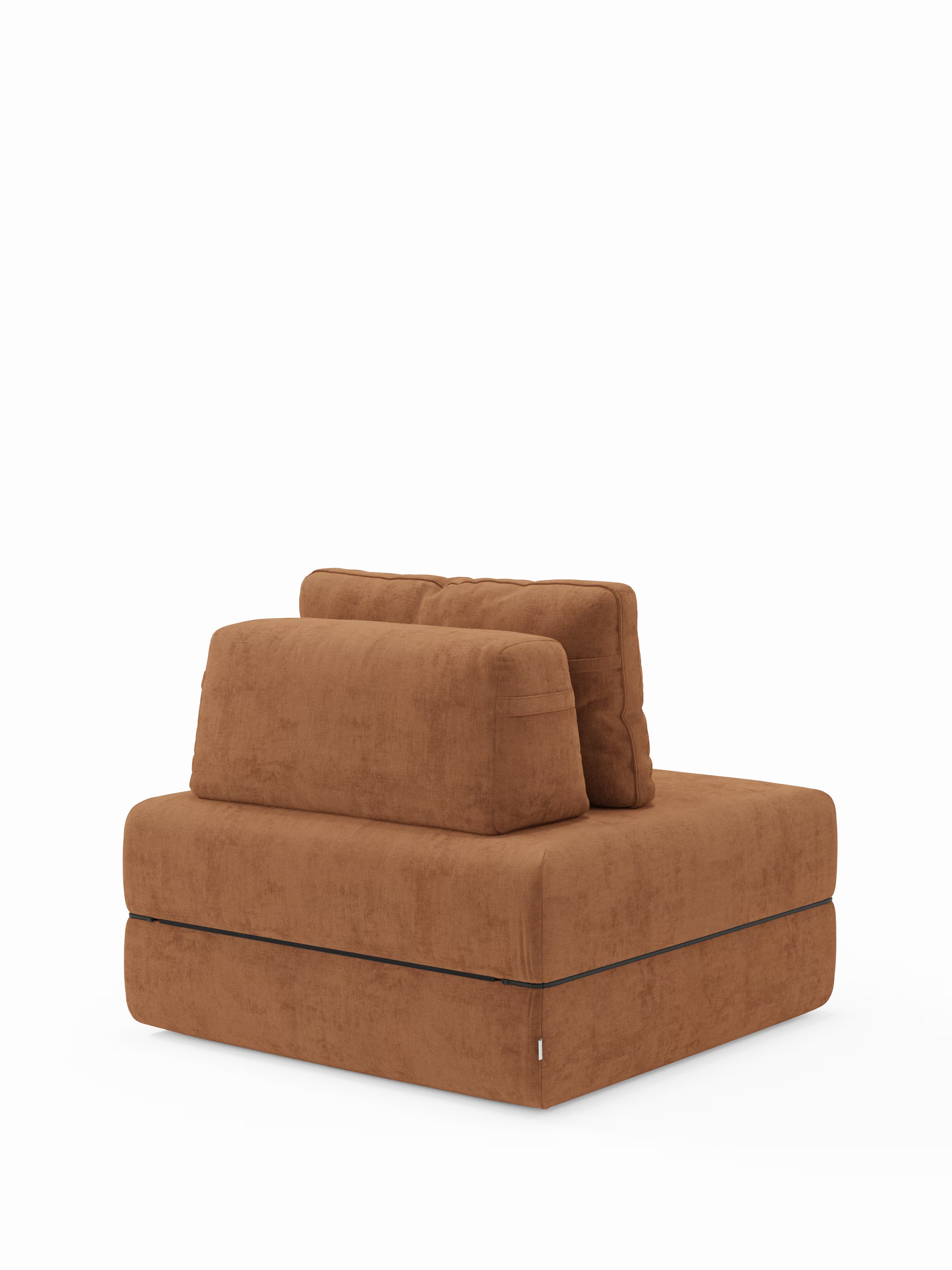 Una poltrona modulare color ruggine di Divani.Store, la “Rift poltrona letto”, è dotata di un materasso in memory foam alto 22 cm, di uno schienale regolabile ed è rivestita in tessuto testurizzato T31 antimacchia; nella foto è raffigurata senza braccioli e su uno sfondo bianco a tinta unita.
