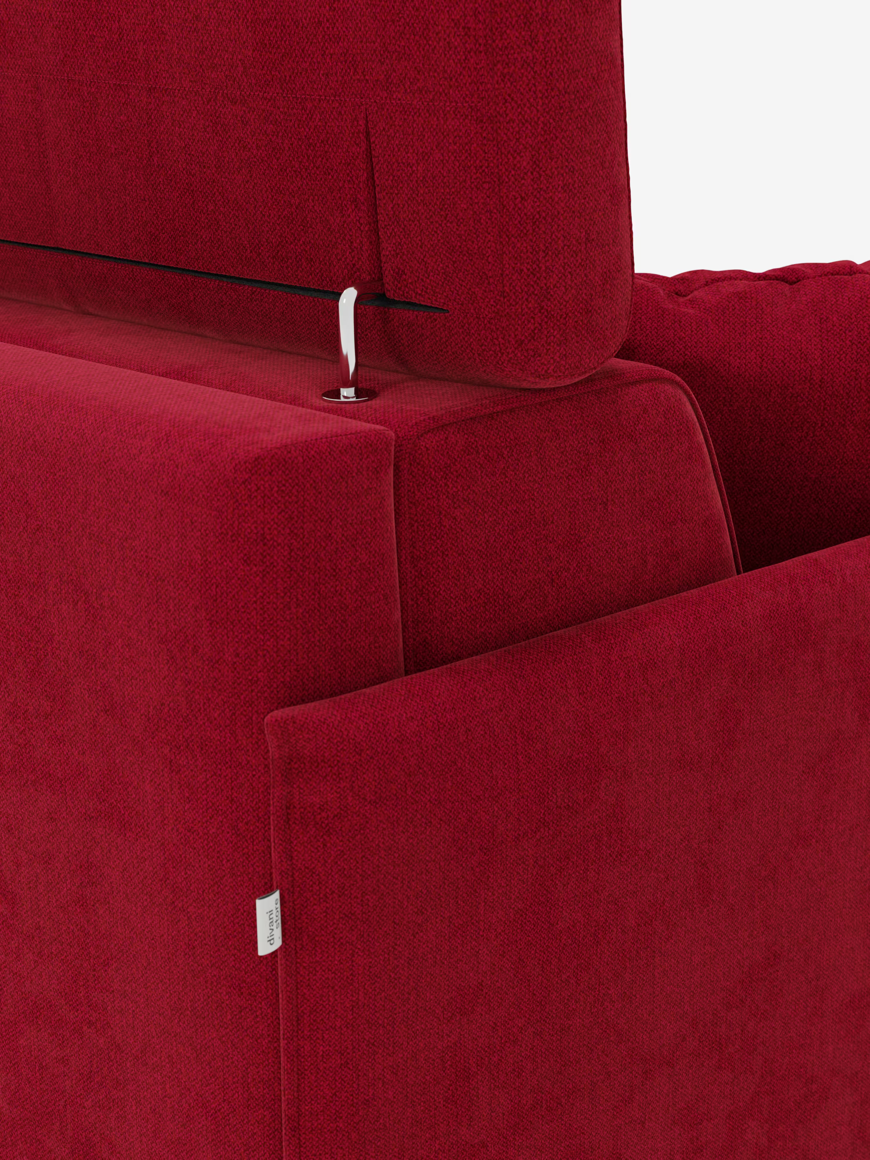 Primo piano di un divano letto matrimoniale "Sole" di Divani.Store, dal design compatto e rivestito in rosso, che mette in risalto lo schienale con il suo meccanismo regolabile per il poggiatesta: un piccolo gancio e un filo metallico collegano il poggiatesta allo schienale. Sul bracciolo è applicata un'etichetta in tessuto bianco. Lo sfondo è bianco a tinta unita.