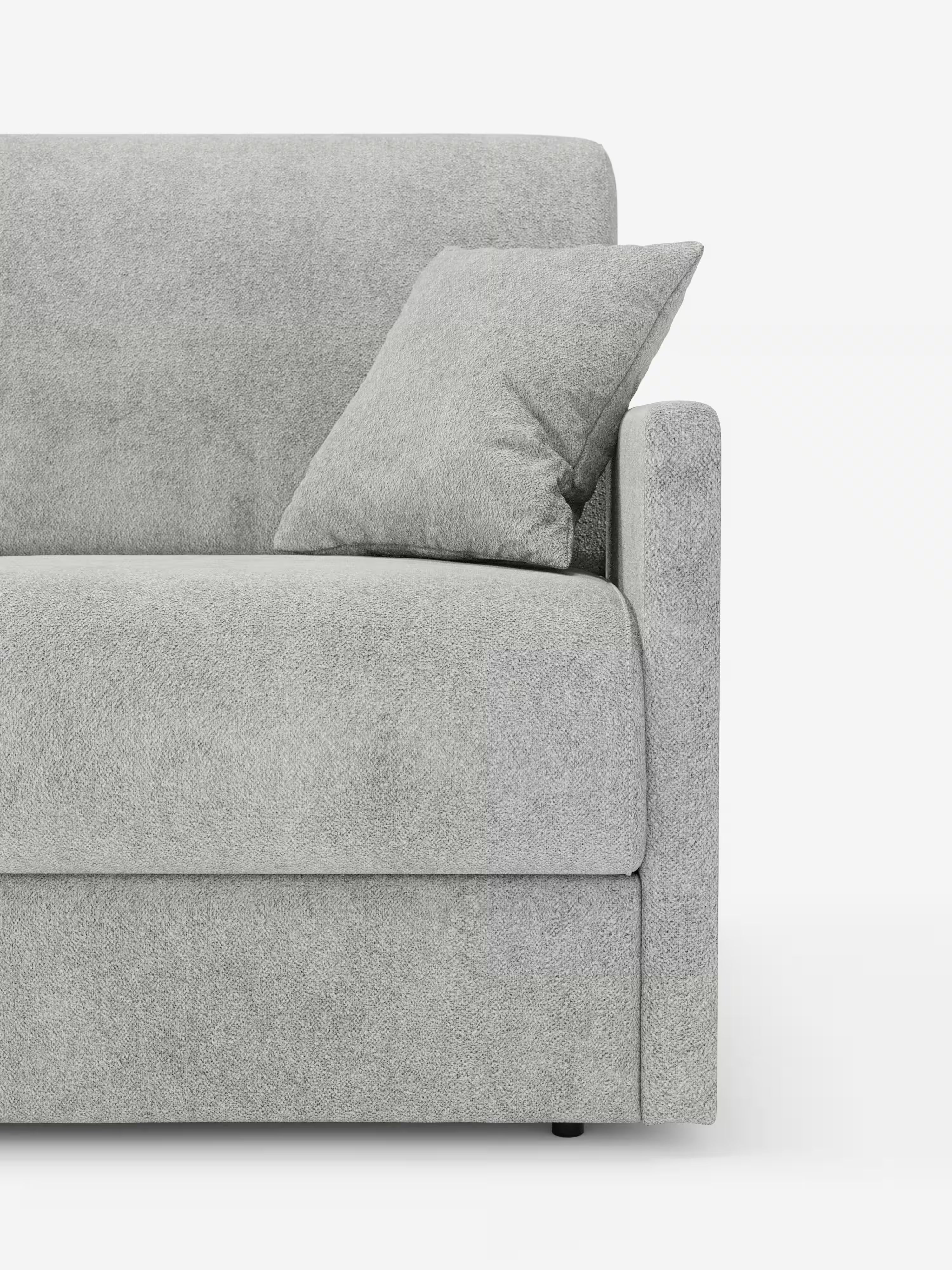 Primo piano del lato destro del divano letto Tommy Divano a 2 e 3 posti matrimoniale di Divani.Store, rivestito in tessuto T33 simile al cotone, resistente alle macchie, di colore grigio chiaro e sfoderabile al 100%. Un cuscino coordinato è appoggiato allo schienale, mentre il bracciolo dritto e imbottito aggiunge comfort. Lo sfondo bianco a tinta unita mette in risalto la trama e il colore di questo moderno divano letto.
