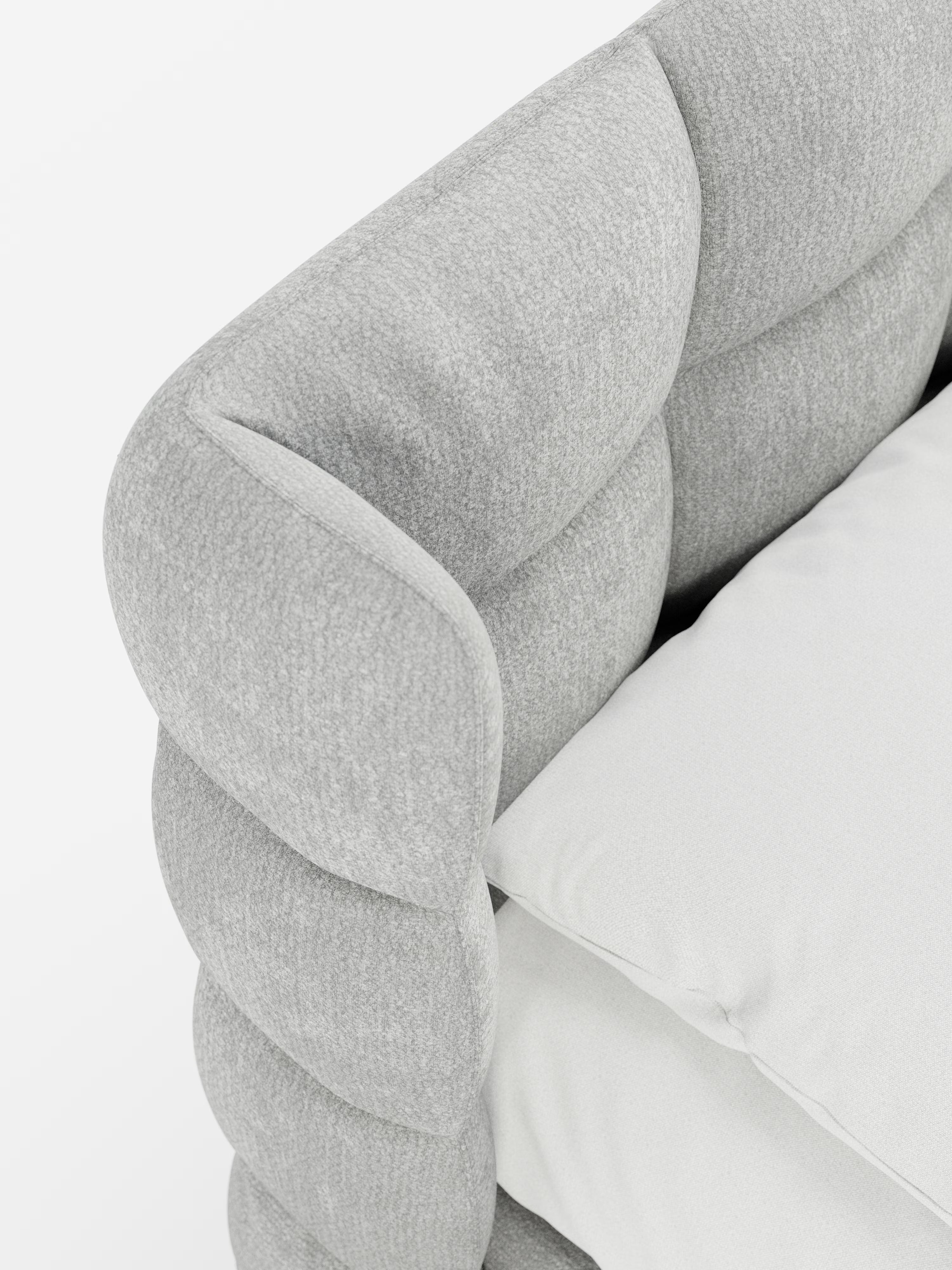 Primo piano del letto imbottito RAGNAR di Letti.store, caratterizzato da un elegante rivestimento in tessuto grigio chiaro certificato Oeko-Tex®. L'immagine mette in risalto i braccioli spessi, morbidi e trapuntati e la testiera capitonné, morbida e avvolgente. Due cuscini color avorio poggiano sulla superficie della seduta, creando un raffinato contrasto con il rivestimento leggermente arrotondato e dalla trama rigata. Lo sfondo è bianco a tinta unita.