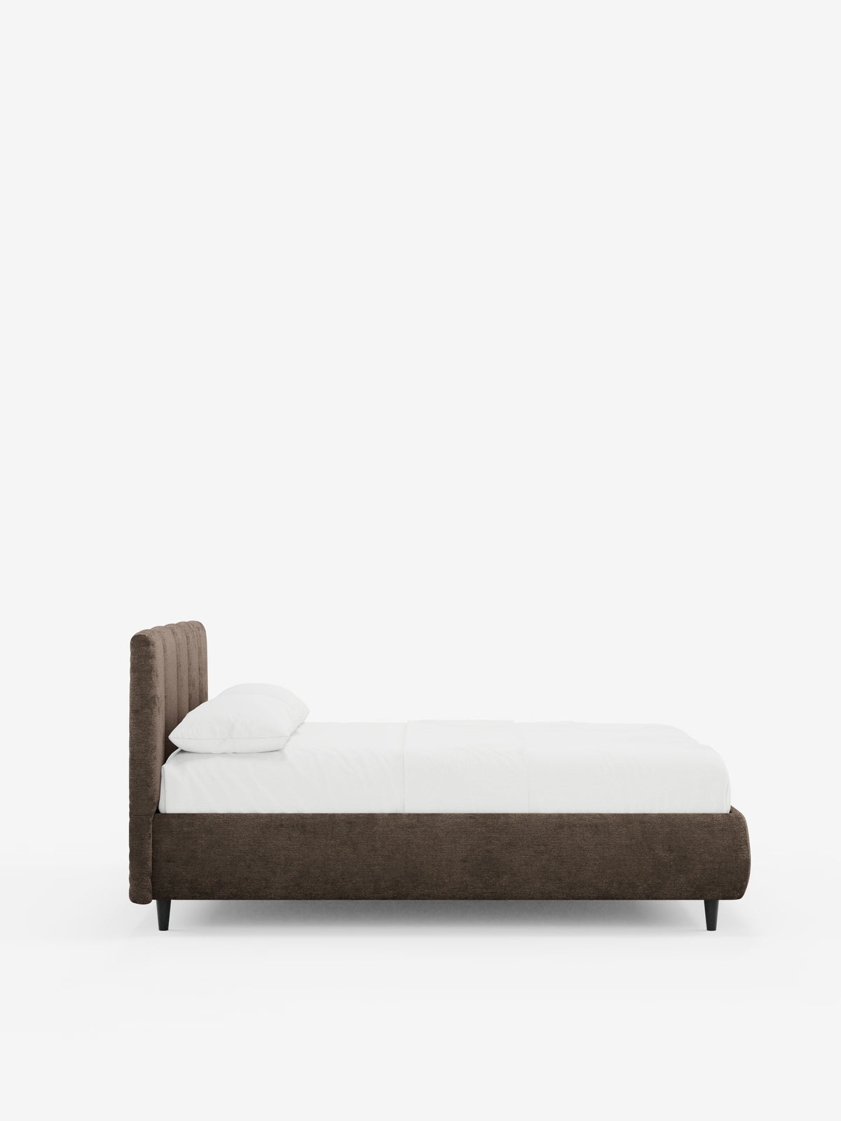 Una vista laterale del letto imbottito ARKAM con contenitore e testiera a lavorazione verticale di Letti.store, caratterizzato da una struttura e una testiera rivestite in tessuto marrone scuro certificato Oeko-Tex® in stile shabby chic, biancheria da letto bianca con un unico cuscino bianco e gambe corte nere, il tutto su uno sfondo bianco a tinta unita.