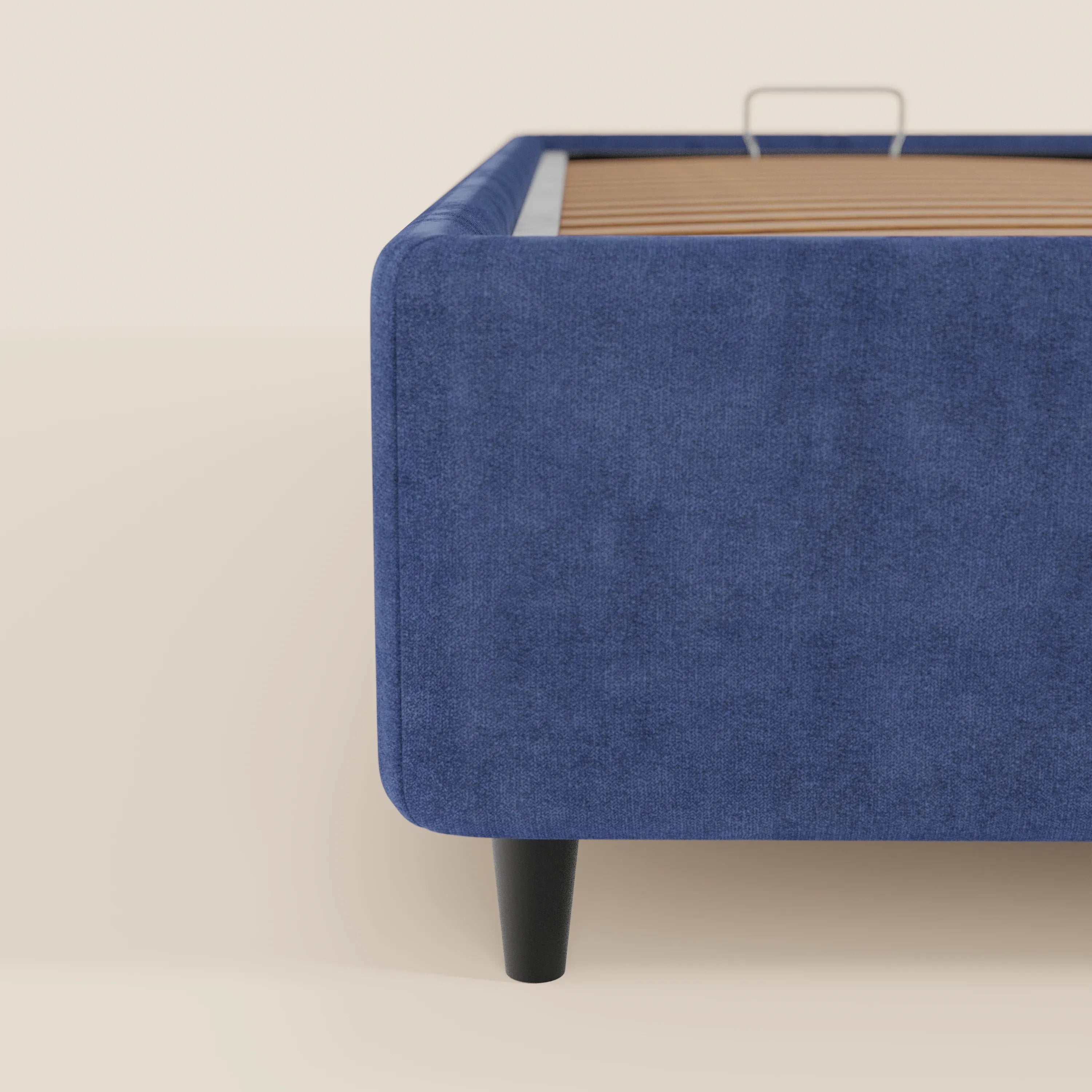 Primo piano del letto sommier imbottito ERON di Letti.store, caratterizzato da un tessuto impermeabile blu certificato Oeko-Tex, gambe affusolate nere e doghe in legno a vista. La sua struttura moderna risalta su uno sfondo chiaro e semplice.