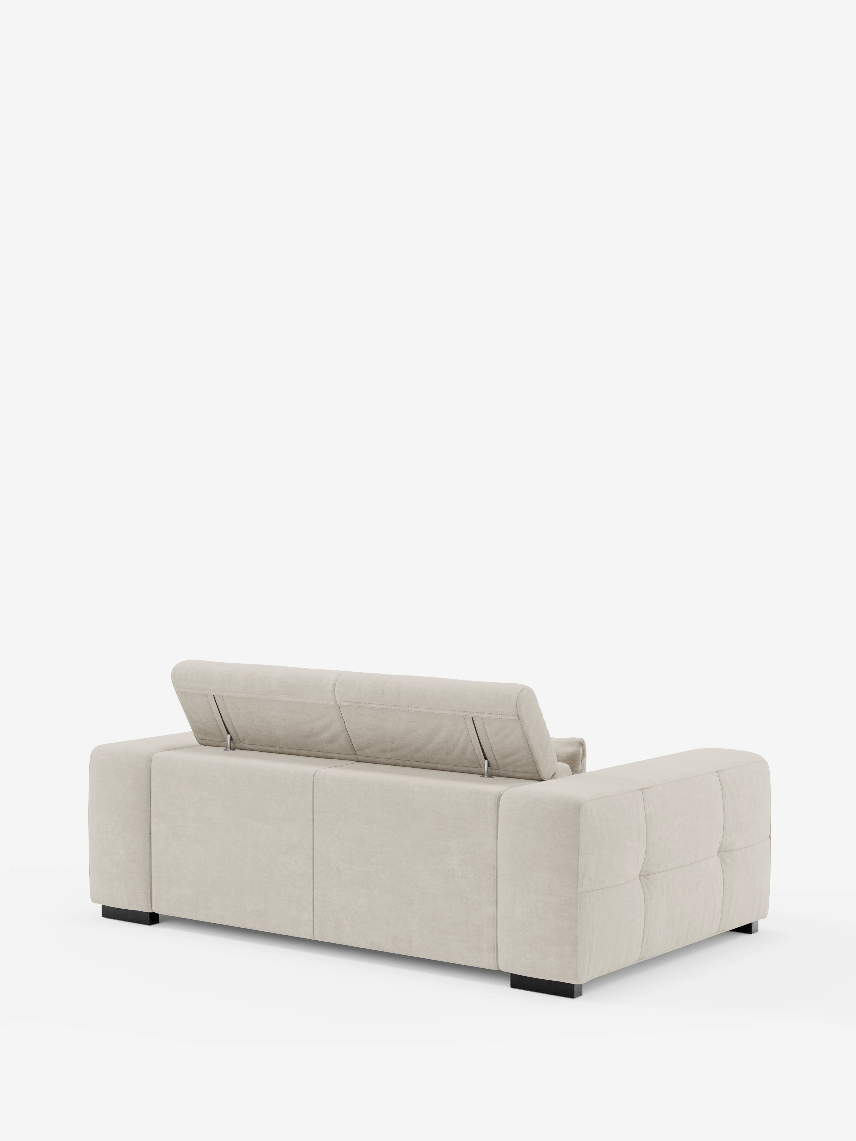 Il divano contemporaneo Monarch con funzione relax elettrica per l'allungamento delle sedute e poggiatesta reclinabile, realizzato in morbido tessuto smacchiabile T31 da Divani.Store, in una tonalità beige chiaro, presenta una silhouette squadrata e morbidi braccioli trapuntati. Il divano presenta angoli squadrati, poggiatesta regolabili parzialmente rialzati sullo schienale e poggia su bassi piedini neri su uno sfondo bianco.
