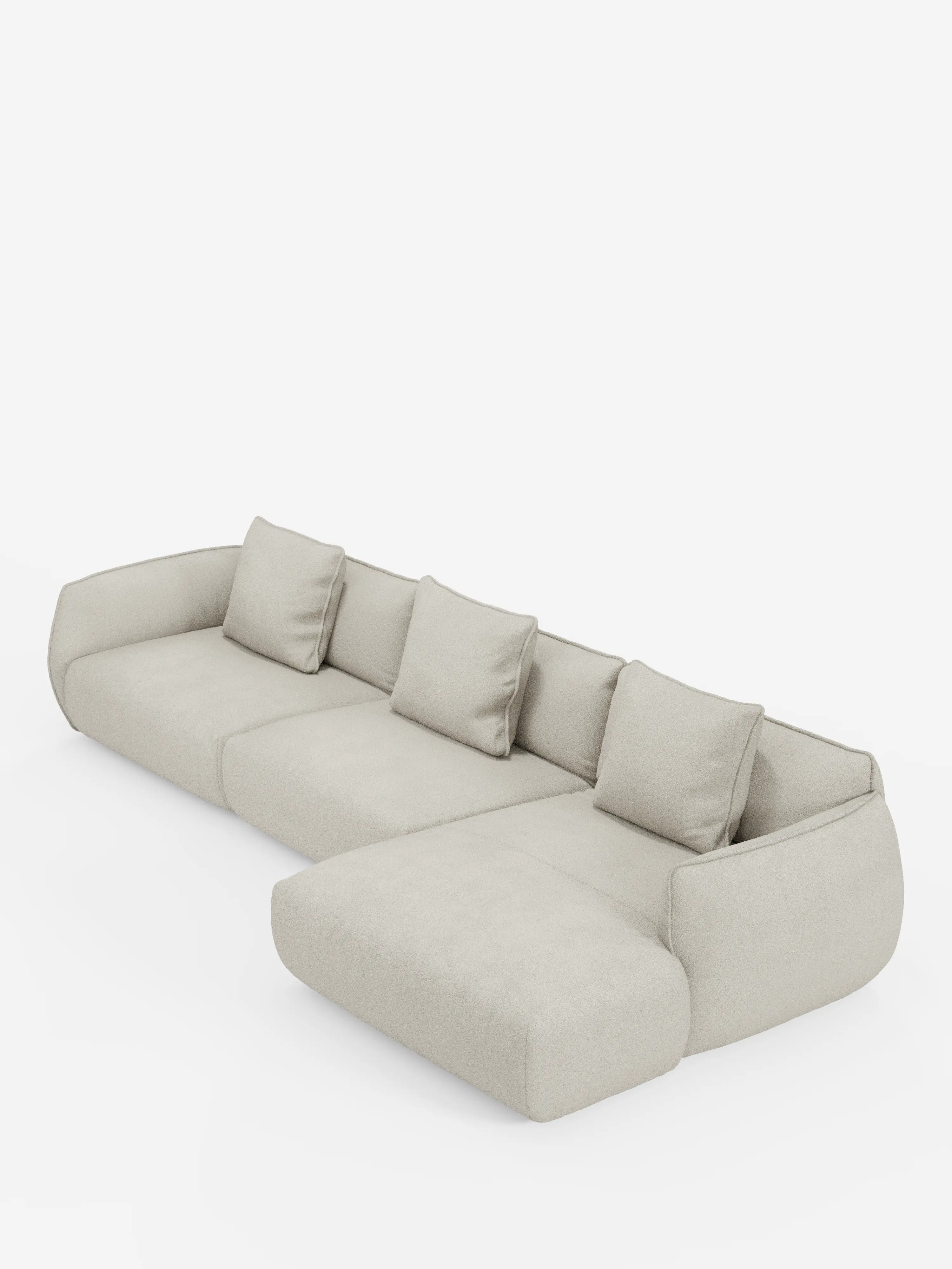 Un moderno divano angolare Nimbus con penisola componibile, rivestito in morbido tessuto effetto cotone smacchiabile T33 di Divani.Store, presentato in una tonalità beige chiaro con quattro cuscini dello schienale e una chaise longue allungata sul lato destro, su uno sfondo bianco a tinta unita.