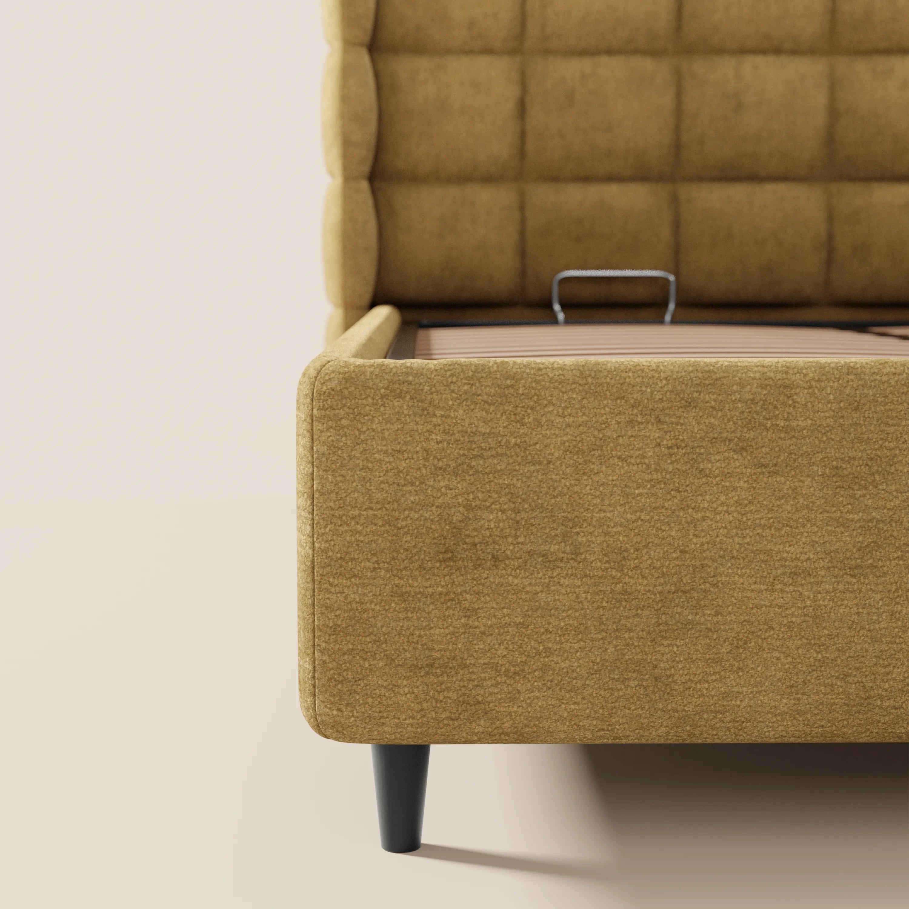 Un primo piano di RAGNAR di Letti.store, un moderno letto imbottito con contenitore e testiera capitonné avvolgente in elegante tessuto Oeko-Tex®, che mostra la testiera a motivo a griglia, la sponda laterale, la gamba nera e la struttura interna di sostegno del letto su uno sfondo beige.
