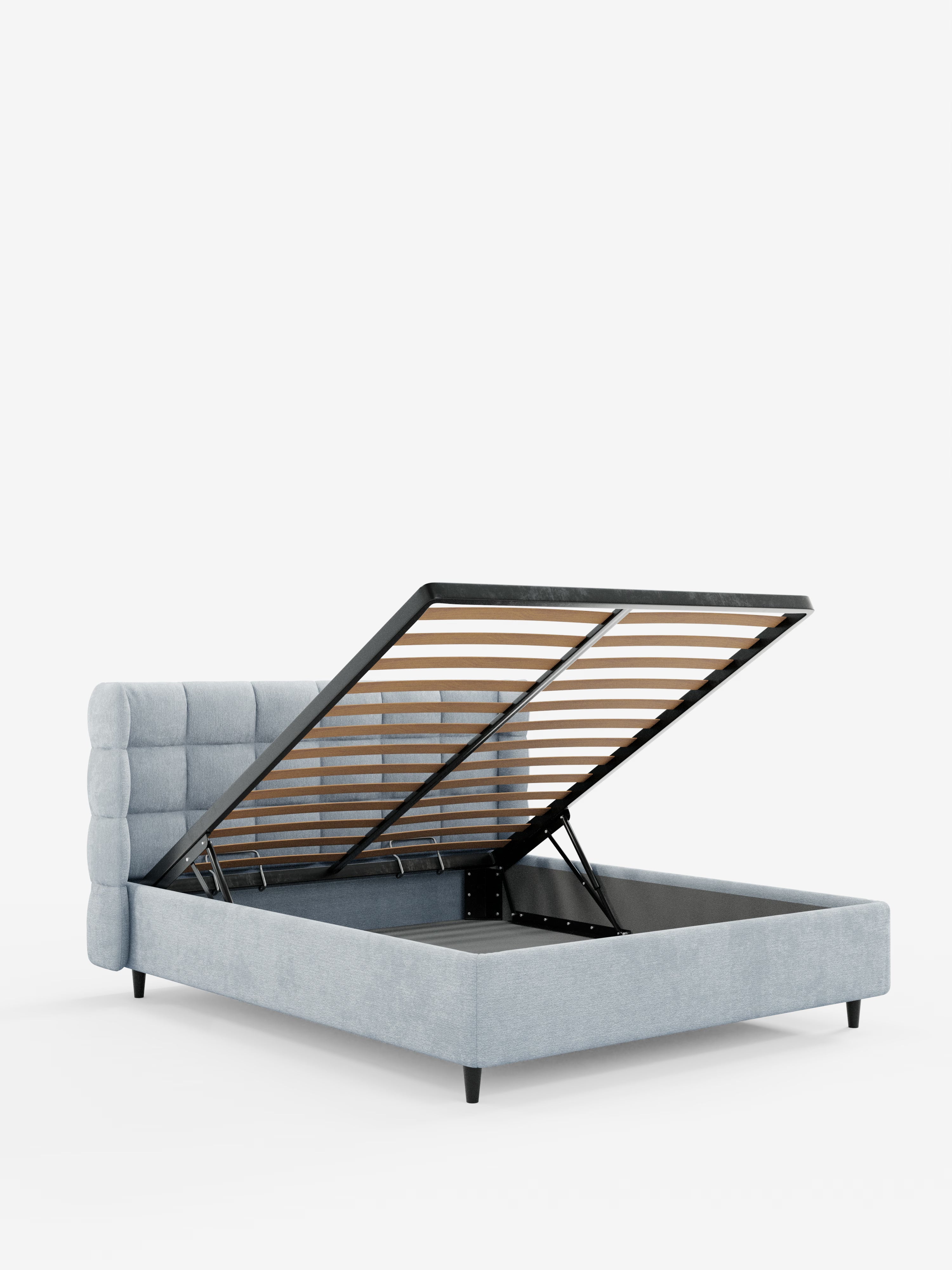 Il letto imbottito RAGNAR con contenitore e testiera capitonné avvolgente di Letti.store è realizzato in tessuto grigio chiaro certificato Oeko-Tex®. Questo elegante letto contenitore presenta gambe nere e una testiera capitonné. La base del materasso si solleva facilmente, rivelando un ampio vano contenitore sotto il letto sostenuto da cerniere idrauliche con doghe in legno a vista. Il tutto su uno sfondo bianco a tinta unita.