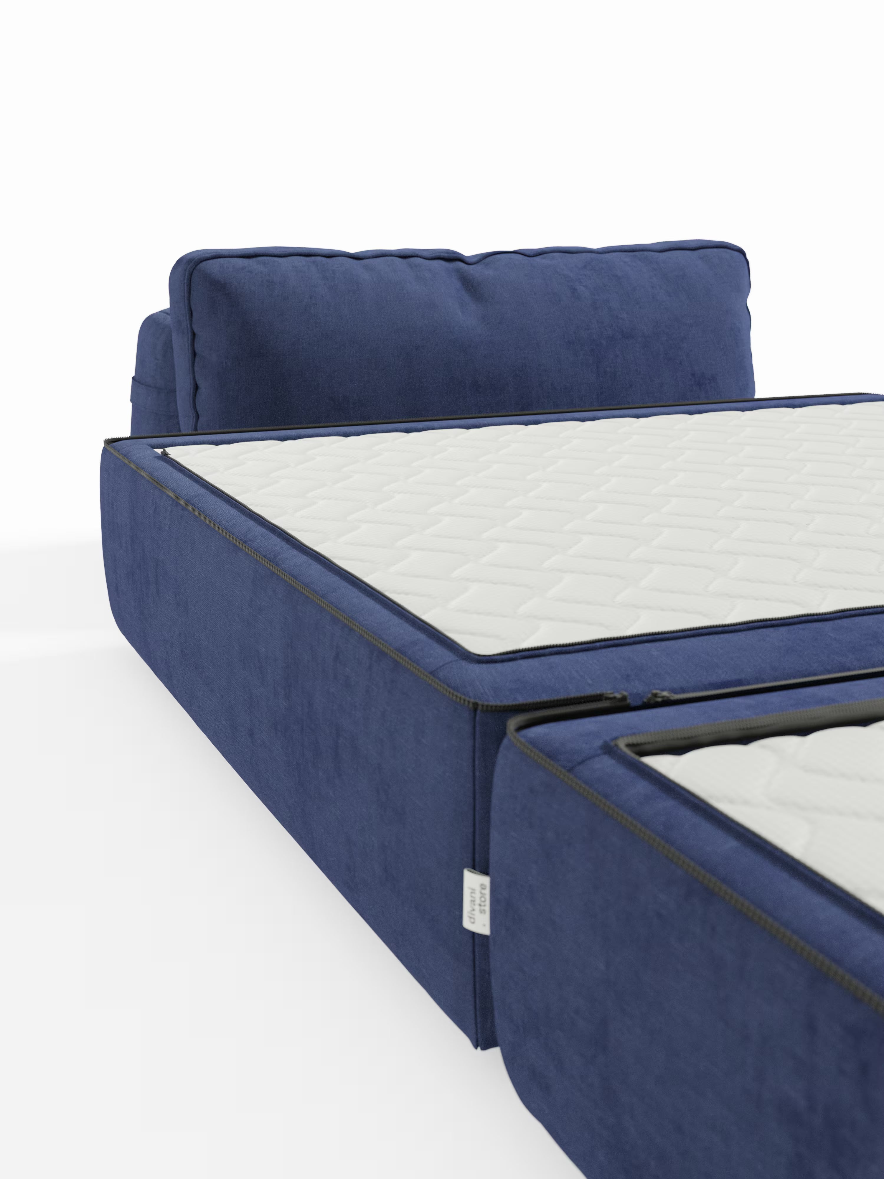 Un moderno letto imbottito blu con materasso trapuntato bianco e testiera abbinata affianca la poltrona-letto Rift con materasso alto 22 cm e memory foam di Divani.Store, caratterizzata da uno schienale mobile e dal tessuto T31 facile da pulire, che coniuga comfort e stile contemporaneo. In primo piano è visibile una parte di un secondo materasso, su uno sfondo minimalista, pulito e ben illuminato.