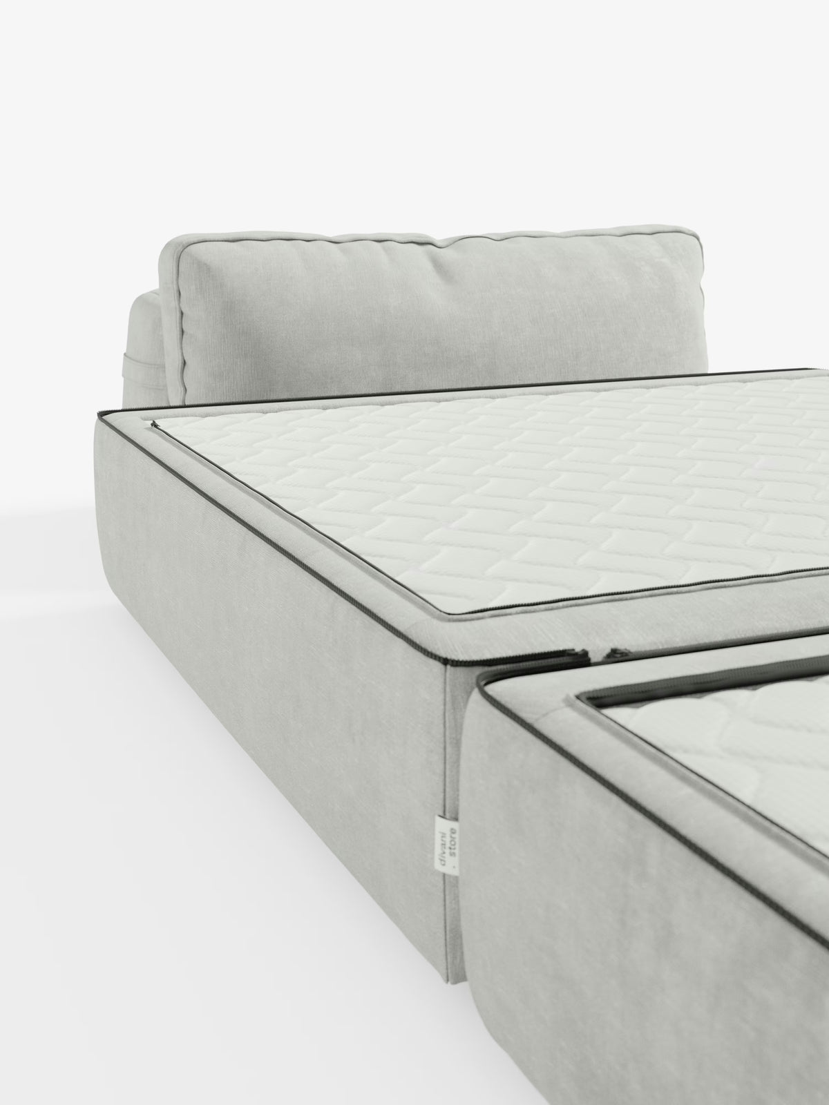 Una poltrona letto Rift in grigio chiaro dal design contemporaneo di Divani.Store, dotata di un materasso in memory foam alto 24 cm e rivestita in tessuto T31 sfoderabile e antimacchia. Il design presenta una superficie trapuntata a trama fitta, un cuscino dello schienale abbinato, eleganti rifiniture in nero e uno schienale regolabile, qui parzialmente visibile su sfondo bianco.