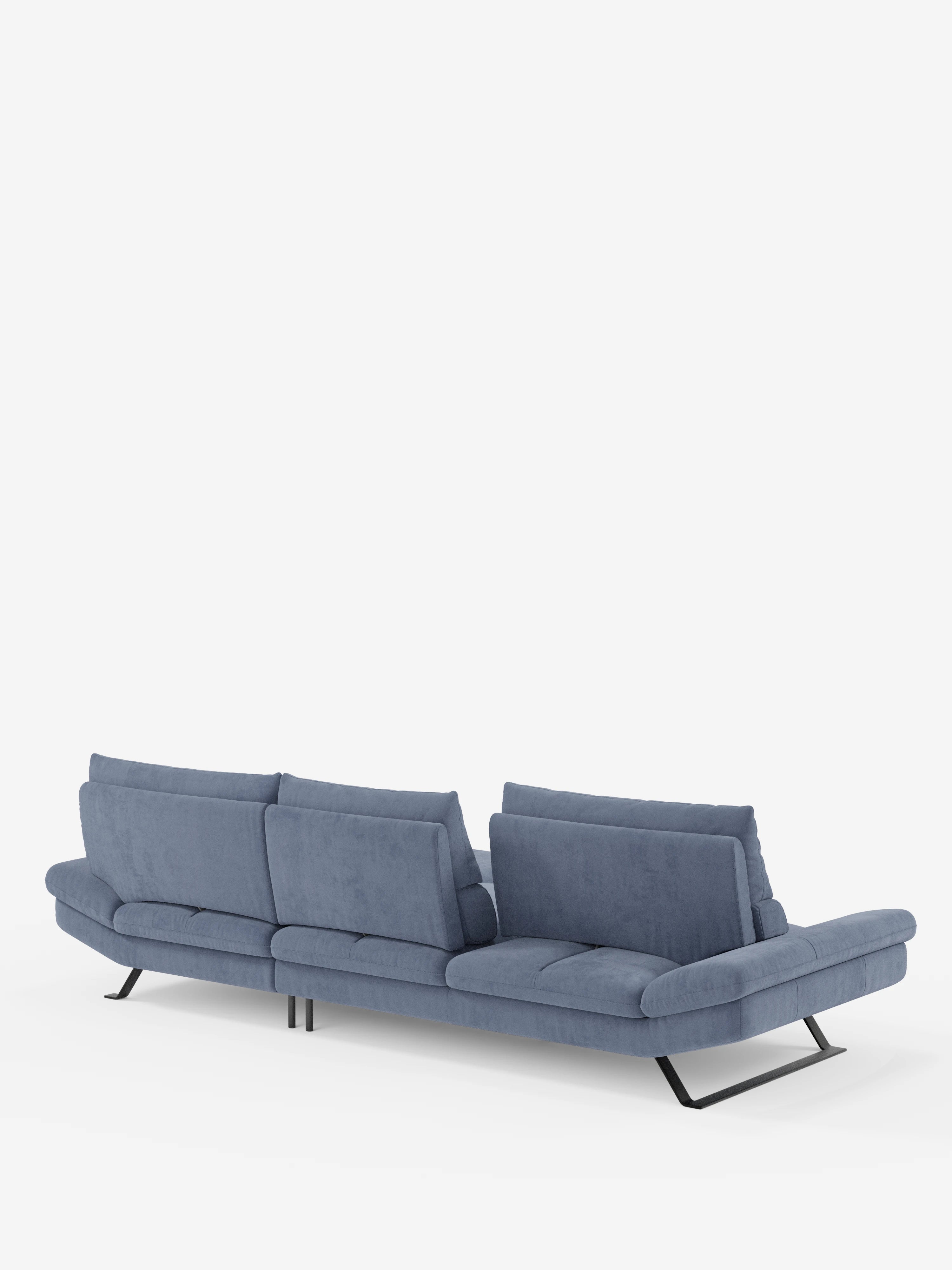 Un divano ad angolo Eclipse blu in stile contemporaneo con chaise longue di Divani.Store è presentato su uno sfondo bianco e fotografato da dietro con una leggera angolazione. Questo divano a tre posti presenta eleganti gambe in metallo e schienali regolabili e traslanti per un comfort personalizzato. Rivestito in morbida microfibra tecnica T11 resistente alle macchie, il suo design è minimalista e sofisticato.