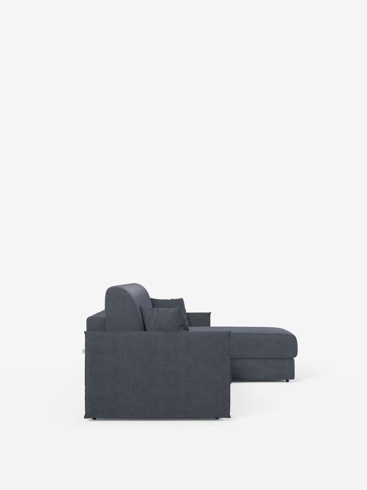 Un divano letto angolare Evans con penisola contenitore di Divani.Store è raffigurato di profilo su uno sfondo bianco a tinta unita. Il divano, di colore grigio scuro, presenta uno schienale basso, ampi braccioli e una chaise longue con penisola contenitore sul lato destro, su cui sono visibili due cuscini quadrati. Il suo design compatto è rivestito in tessuto T23, facile da pulire.