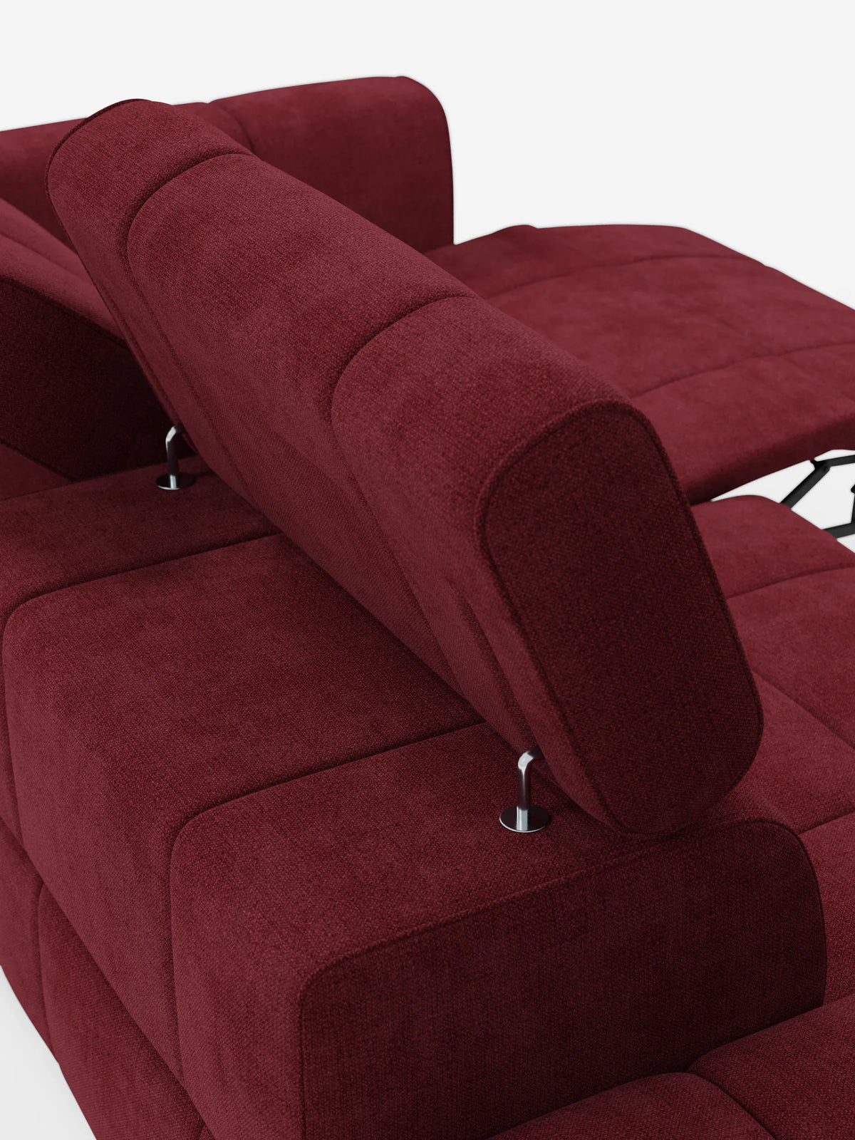 Un moderno divano componibile Giotto color bordeaux con terminale aperto - opzione relax elettrico in tessuto smacchiabile T23 con poggiatesta regolabili, caratterizzato da una sezione allungata con poggiapiedi rialzato che lascia intravedere una struttura metallica bianca.