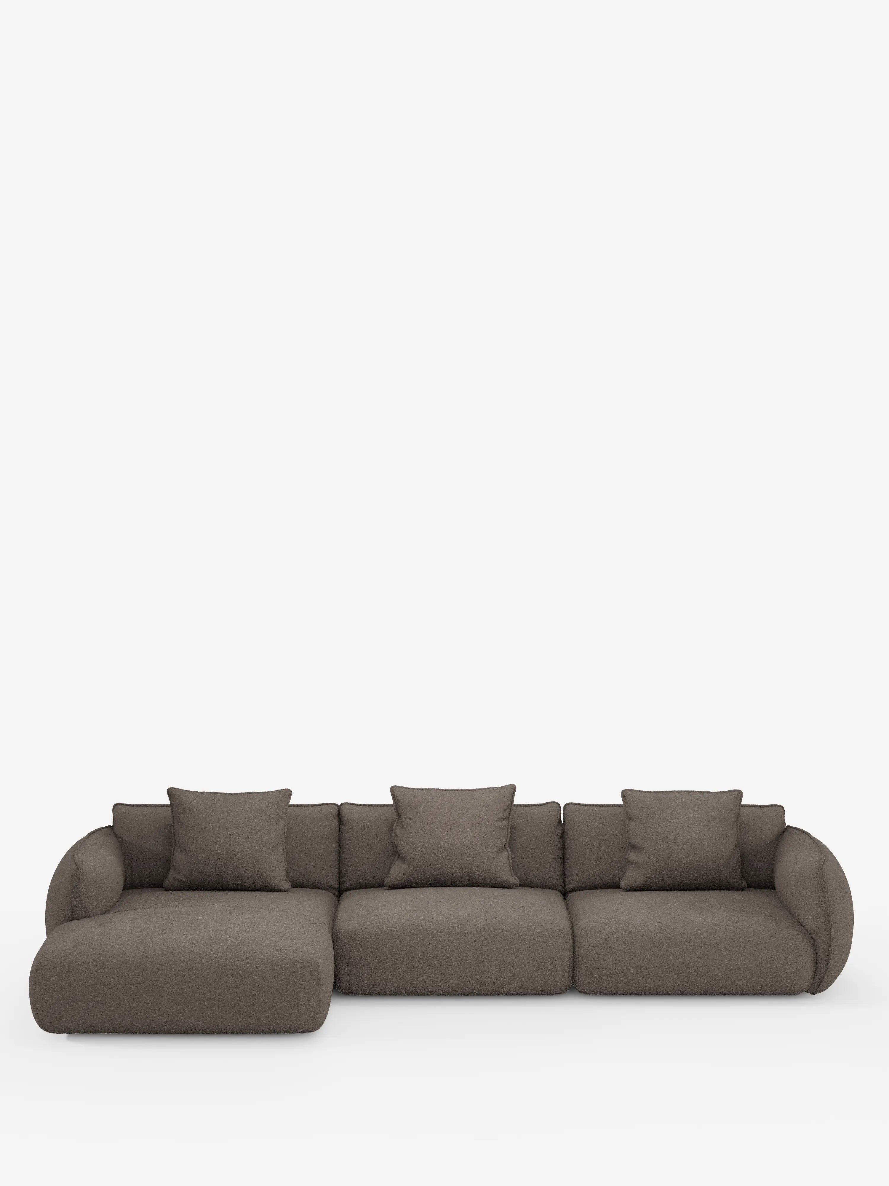 Un moderno divano angolare a tre elementi della linea Nimbus con penisola componibile di Divani.Store, rivestito in tessuto T33 effetto cotone marrone scuro e resistente alle macchie, caratterizzato da braccioli arrotondati, schienali bassi e sei cuscini quadrati coordinati. Il design minimalista e raffinato risalta su uno sfondo bianco a tinta unita.
